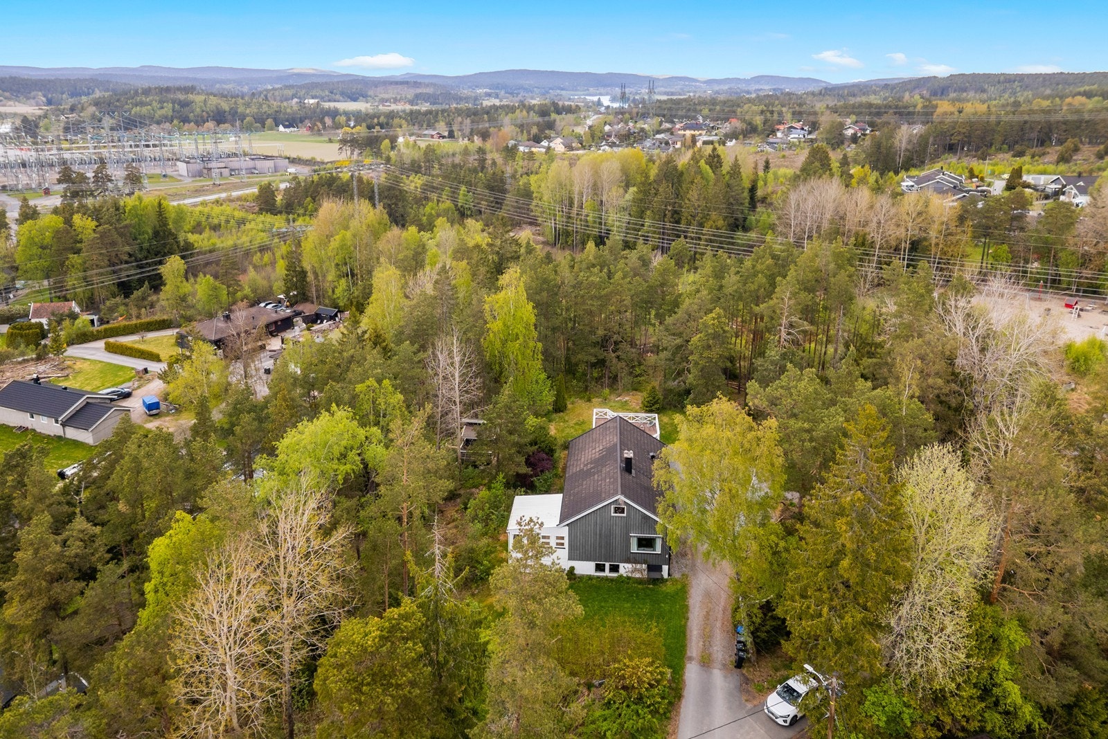 Enebolig over tre plan med en stor, usjenert tomt. Eiendommen er omkranset av natur og har en gruset gårdsplass med integrert garasje. Galleribilde