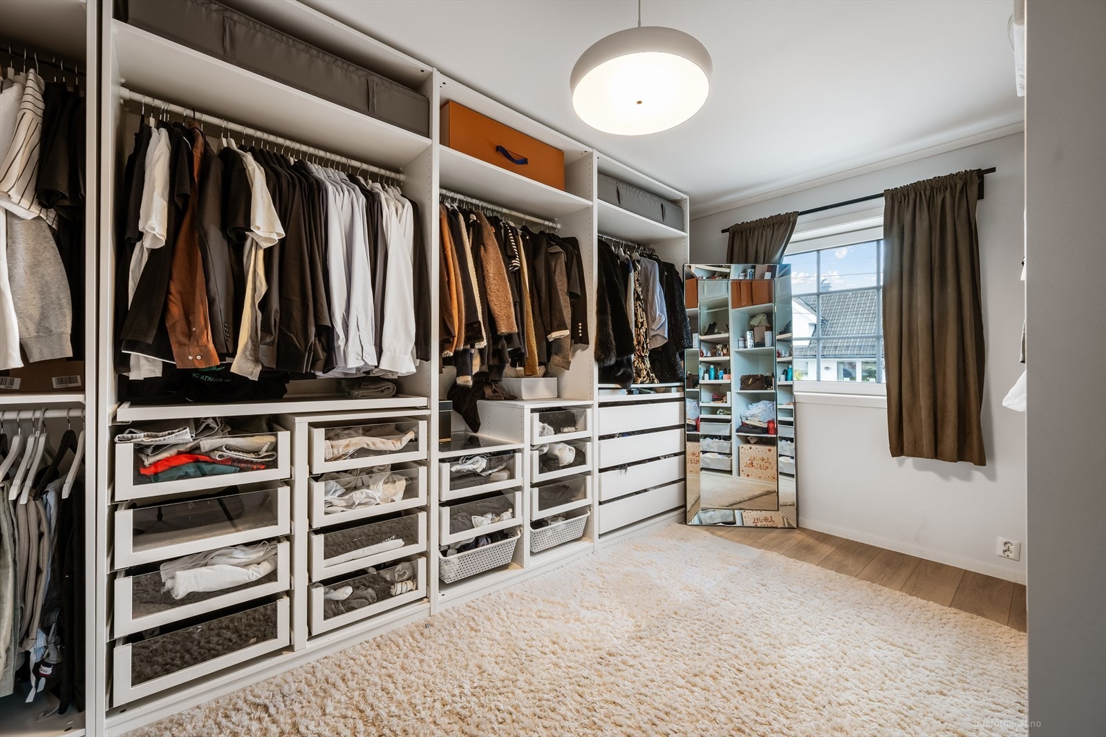 Walk-in closet med skreddersydde garderobeløsninger gir rikelig med oppbevaringsplass. Galleribilde