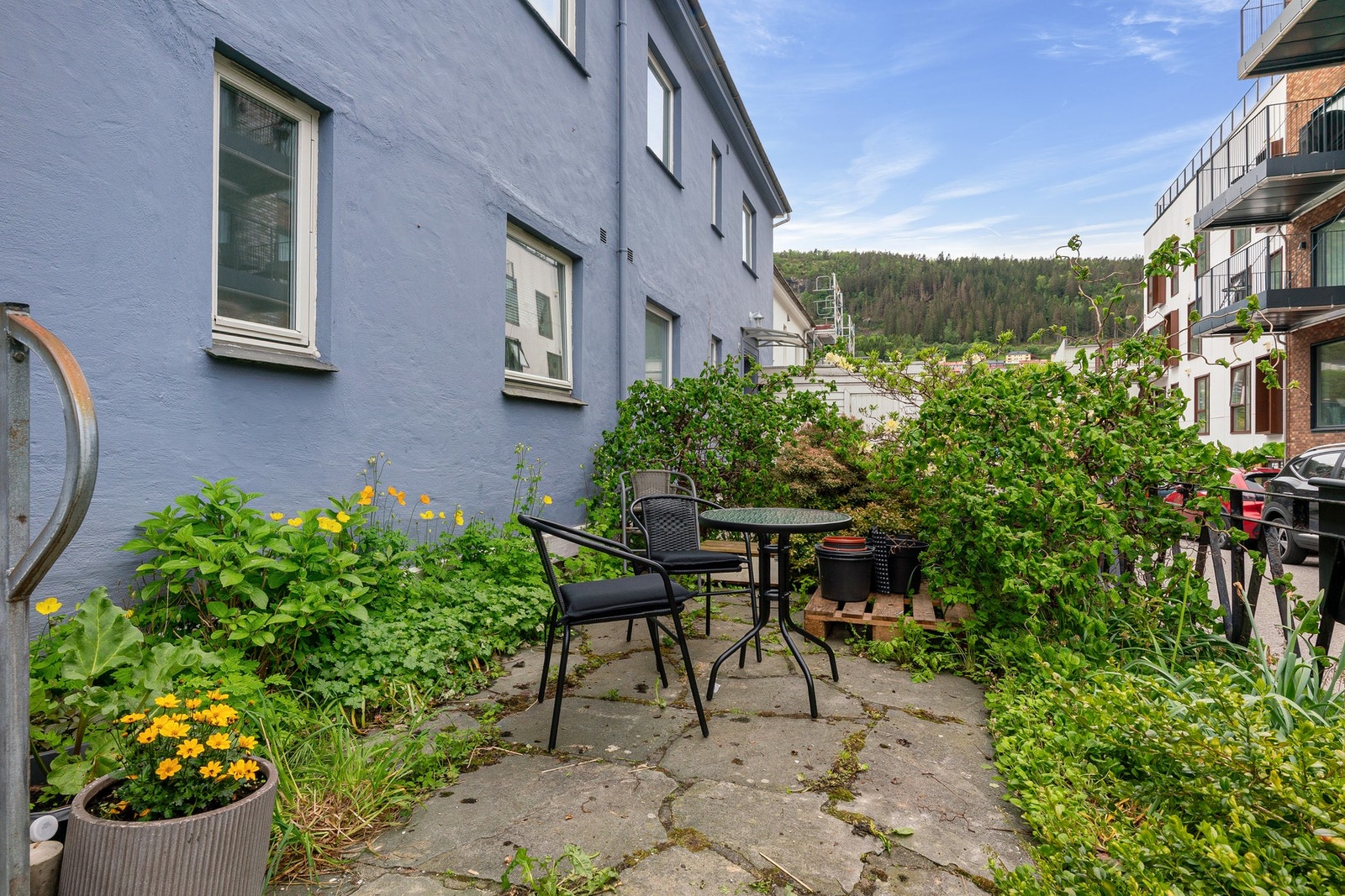 Koselig uteplass ved inngangspartiet, som disponeres av sameierne. Det er nye avløpsrør i husrekken til offentlig knutepunkt i gaten. Galleribilde