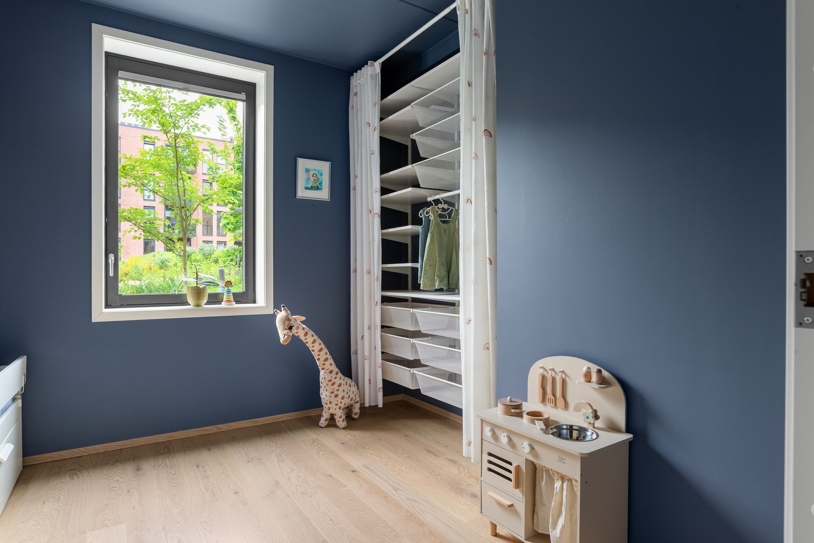 Det er etablert en vegghengt garderobeløsning i nisjen på rommet, gjemt bak gardiner. Galleribilde