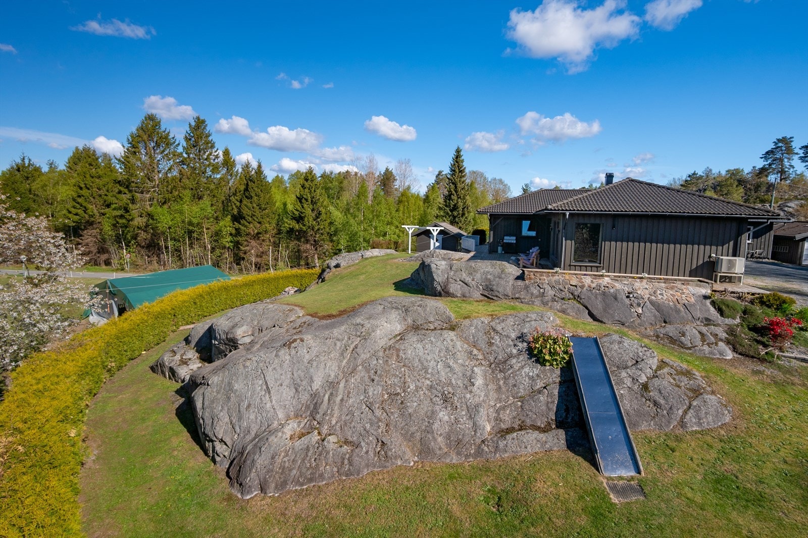 Eiendommen ligger høyt og fritt på en naturtomt med synlig fjell. Galleribilde