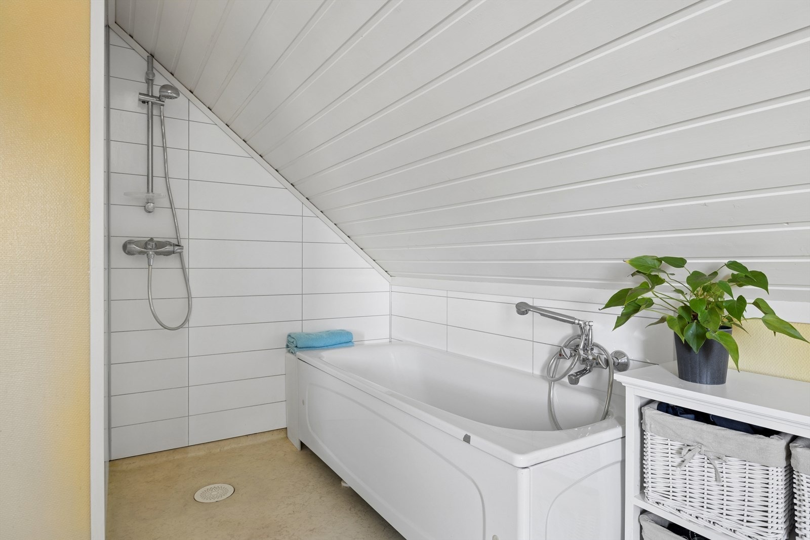 Badet har panelte vegger og tak samt et praktisk dusjhjørne og badekar. Galleribilde