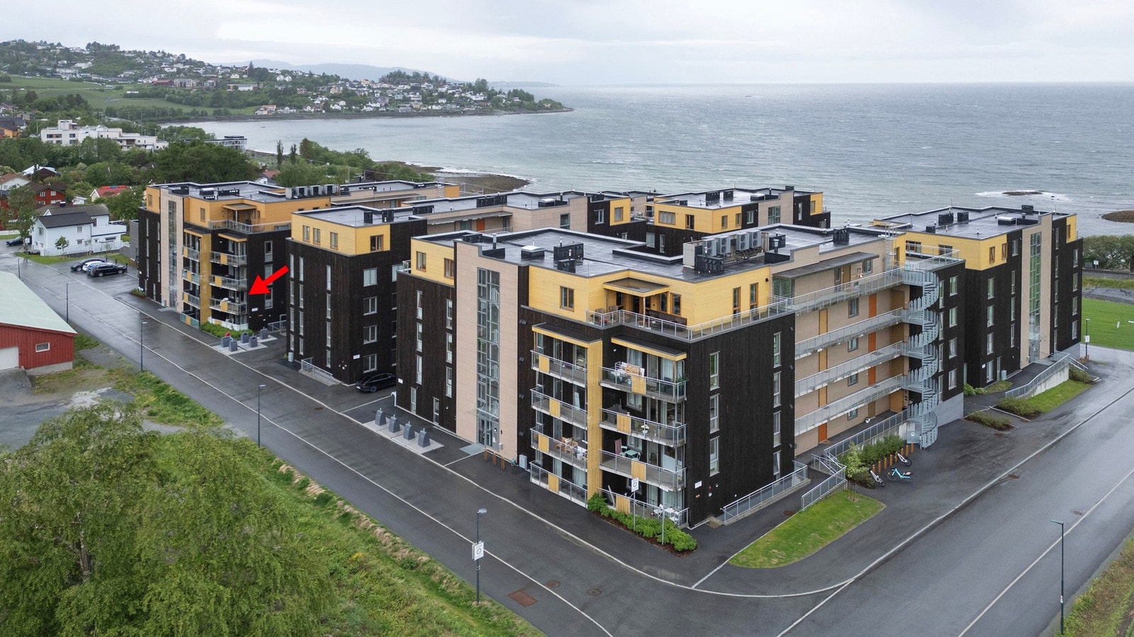 Dronefoto, pilen markerer leilighetens plassering i bygget. Galleribilde