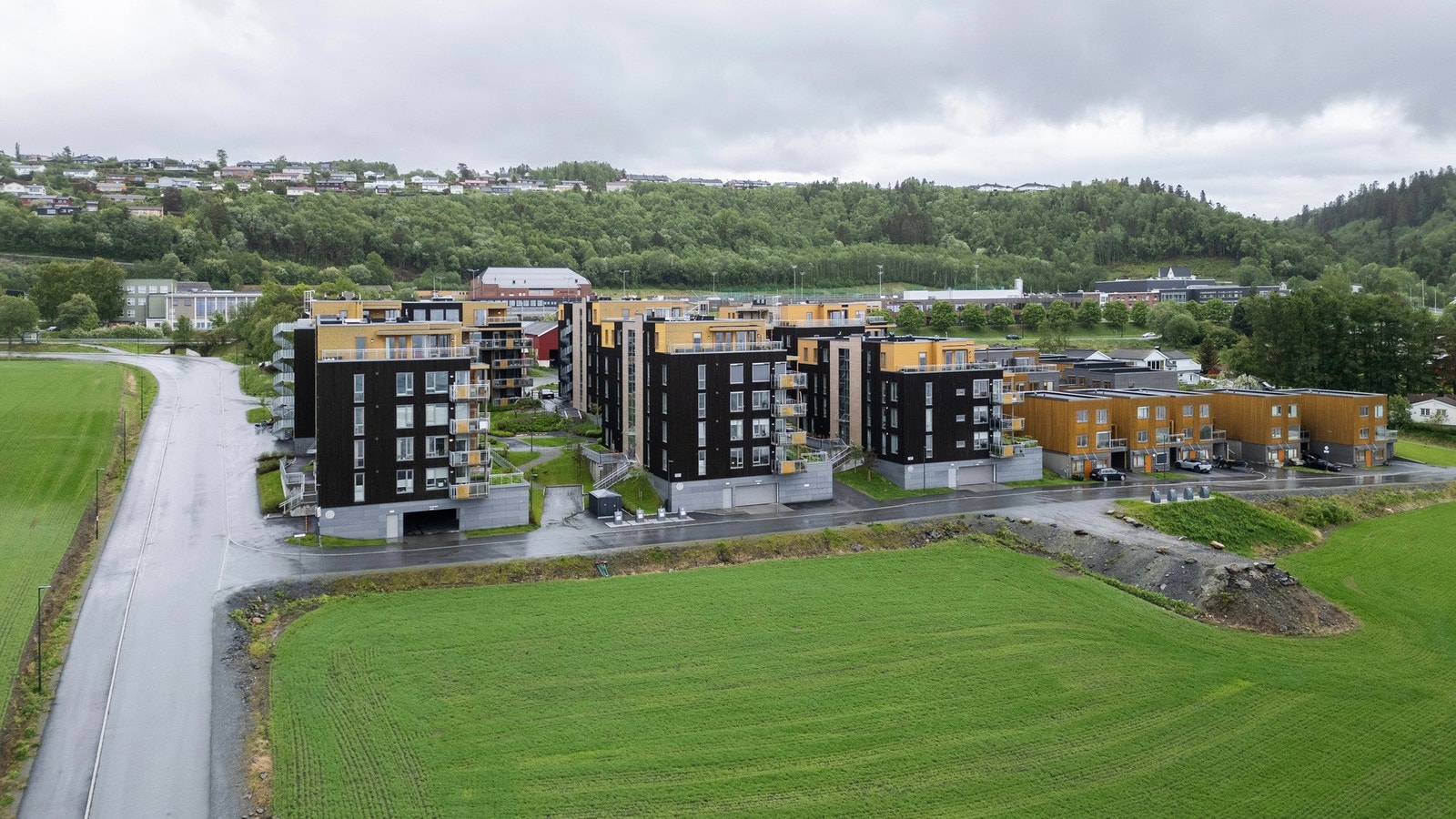 Dronefoto. Leiligheten ligger i et attraktivt og moderne boligområde med grønne omgivelser og kort vei til både servicetilbud, bussforbindelse og rekreasjonsmuligheter. Galleribilde