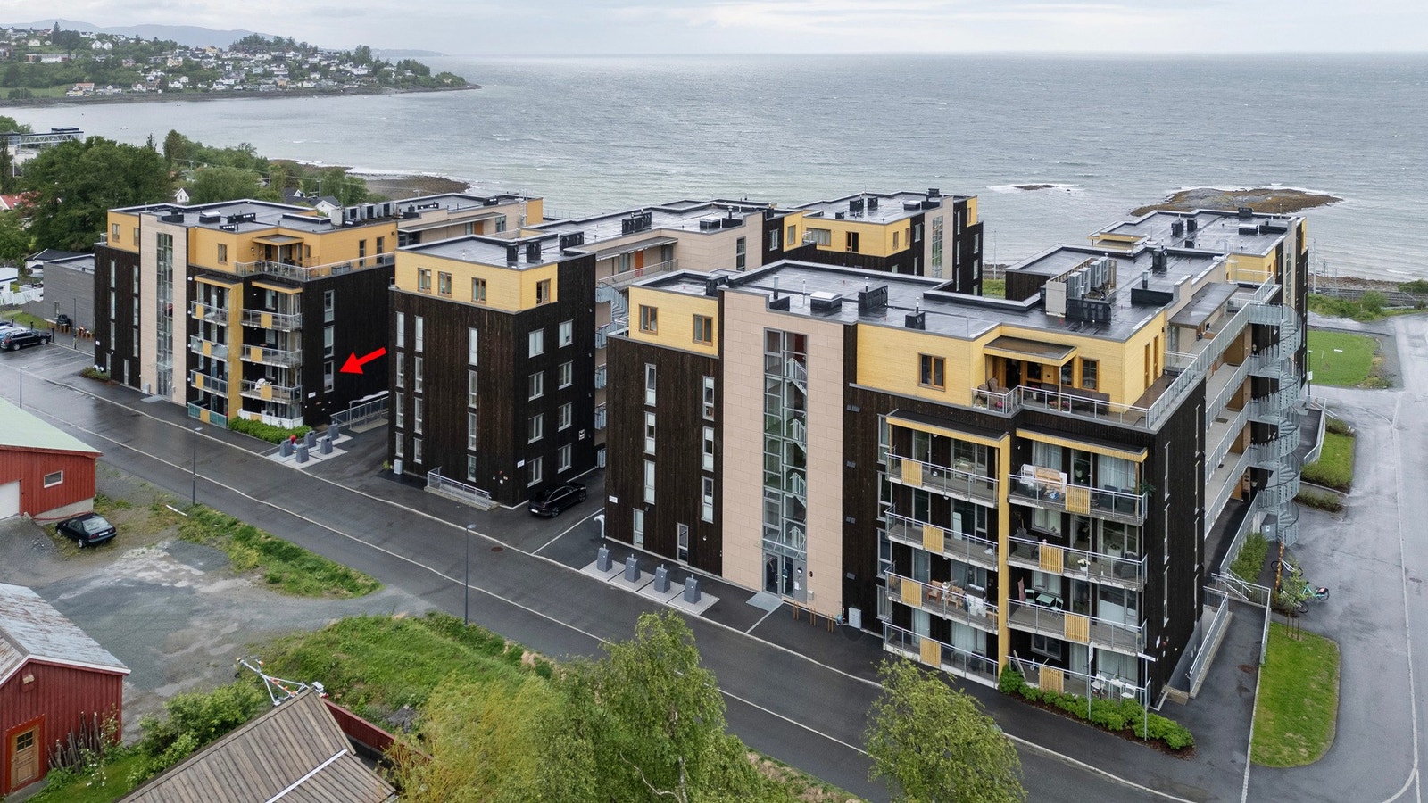 Dronefoto, pilen markerer leilighetens plassering i bygget. Galleribilde