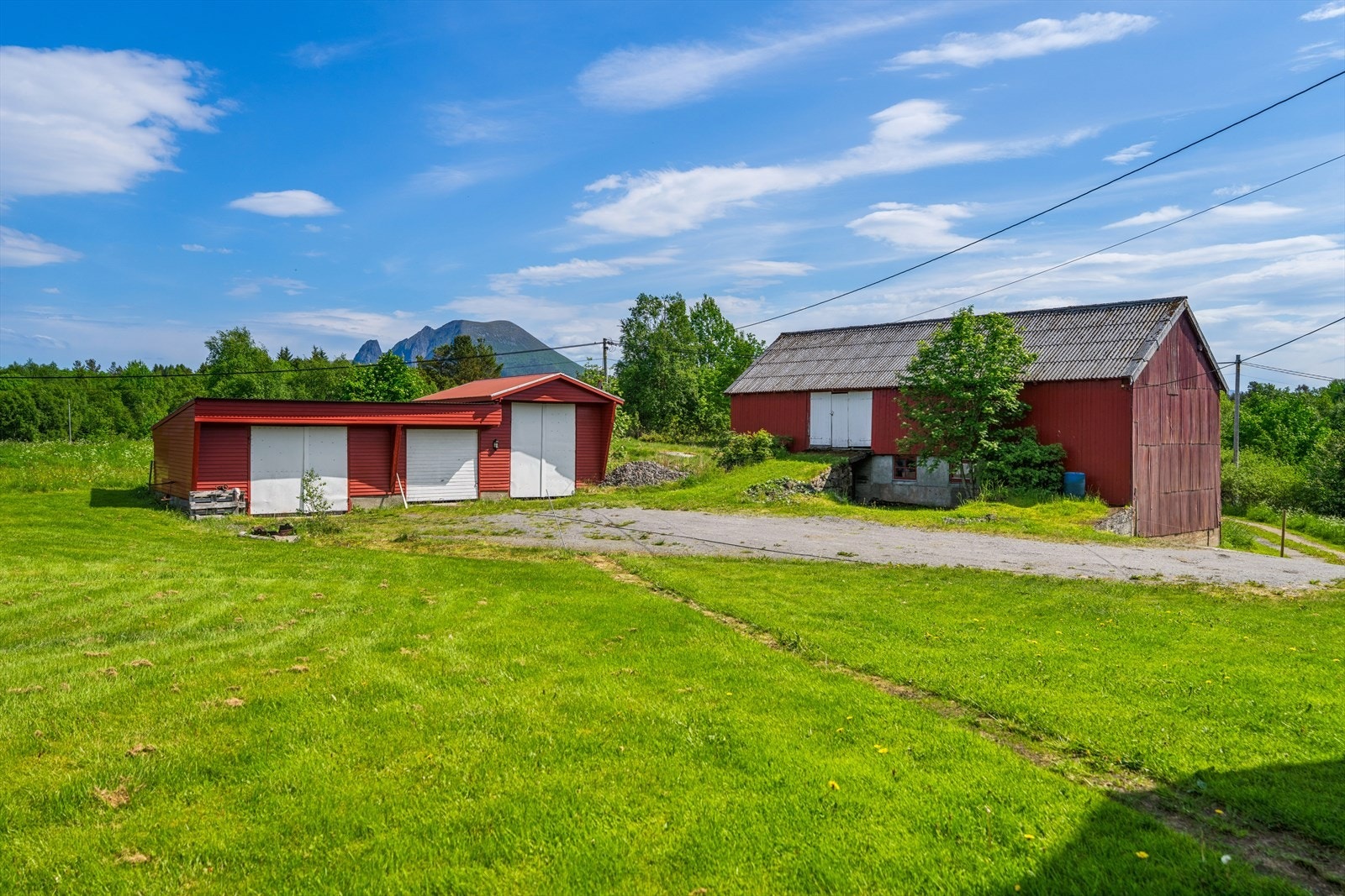 På tunet står en romslig garasje og en eldre låve med stort lagringspotensial. Galleribilde