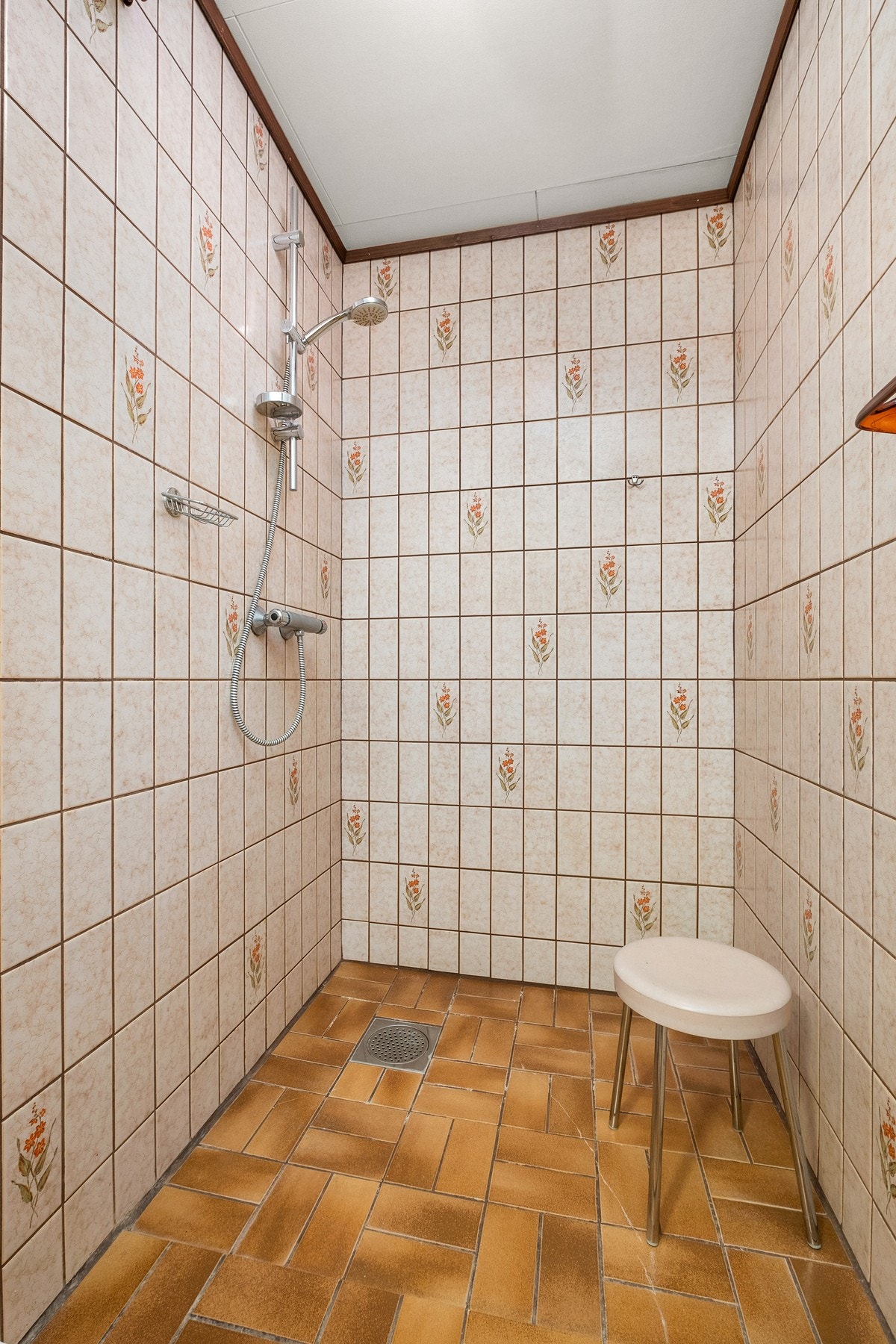 Badet er innredet med gulvmontert toalett, veggmontert servantskål og dusjhørnet. Galleribilde