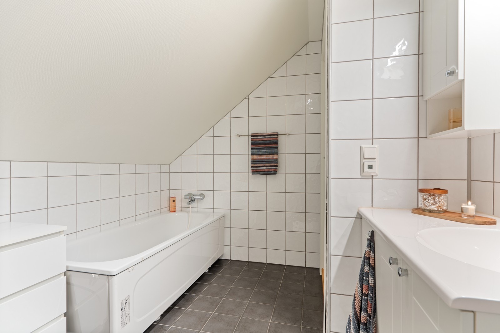 Badet er innredet med baderomsseksjon bestående av servant og skap, badekar samt gulvstående toalett. Galleribilde
