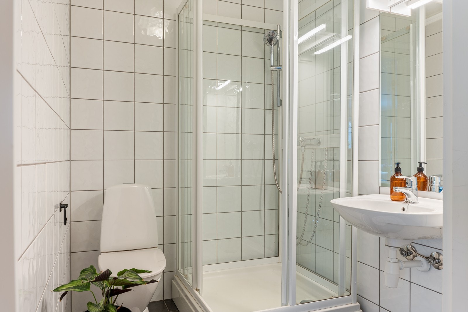 Badet er flislagt med varmekabler i gulv og fremstår lyst og funksjonelt. Galleribilde