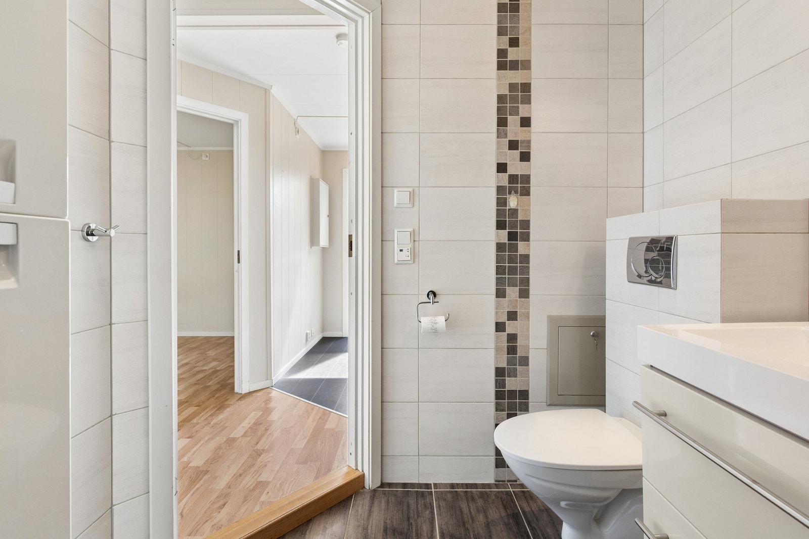 Flislagt gulv med varmekabler bidrar til god komfort gjennom hele året. Baderomsinnredningen gir gode oppbevaringsmuligheter, og det er opplegg for vaskemaskin på badet. Galleribilde