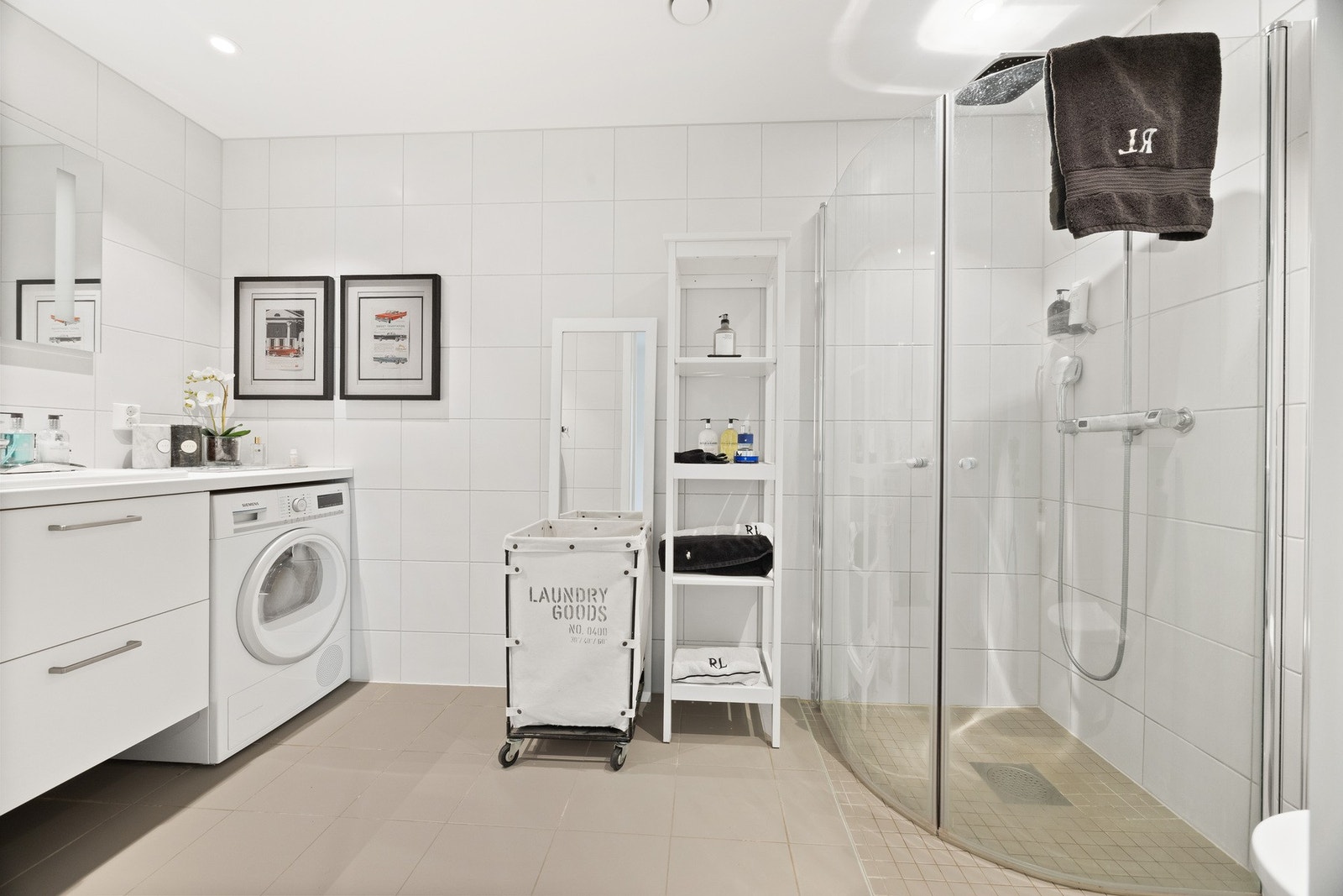 Flislagt baderom med varmekabler i gulv og downlights i himling. Badet er utstyrt med vegghengt toalett, dusjhjørne, servant integrert i skuffeinnredning og speil med lys Galleribilde