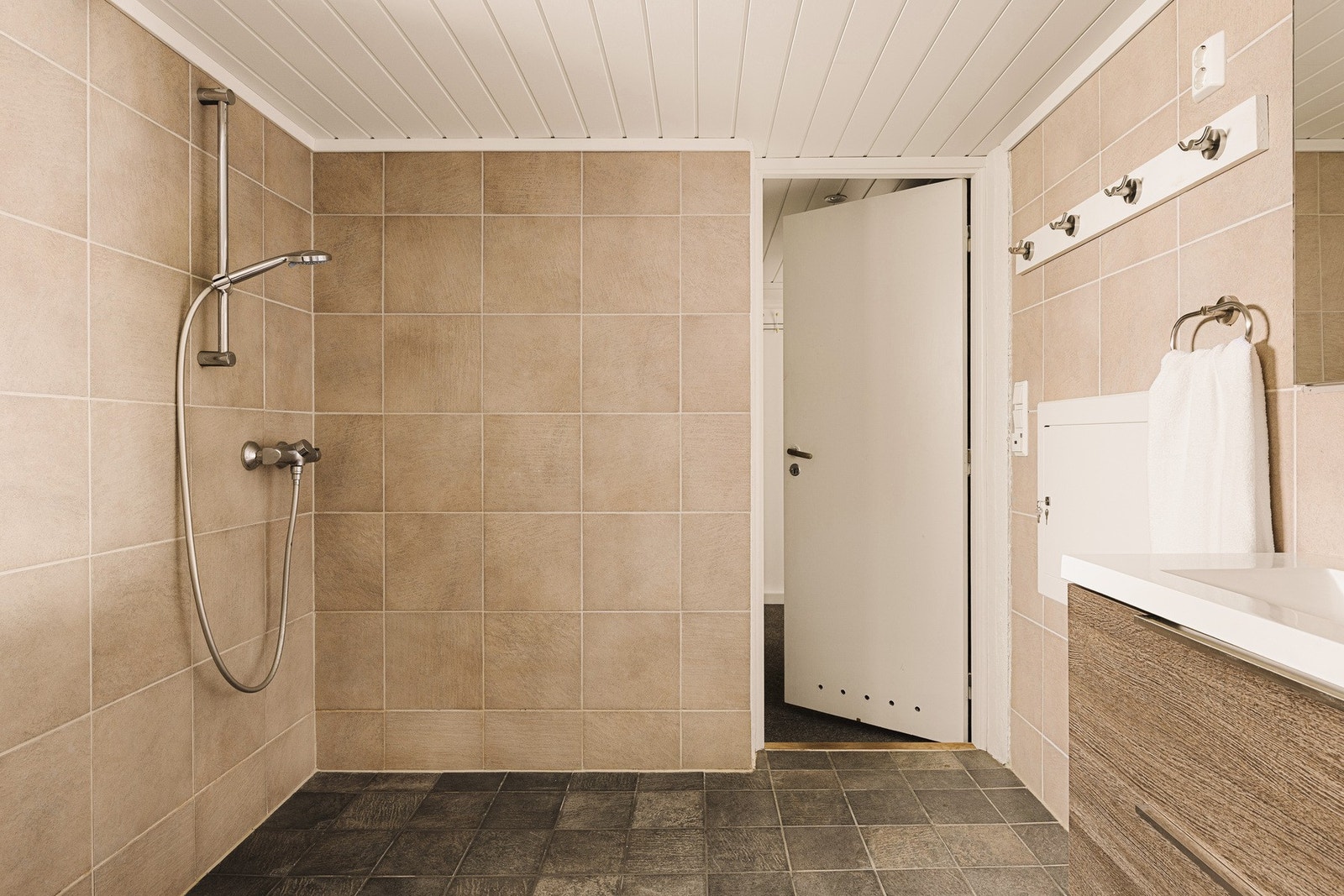 Badet er utstyrt med servantinnredning, høyskap, innebygget speilskap, vegghengt toalett og dusjhjørne. Galleribilde