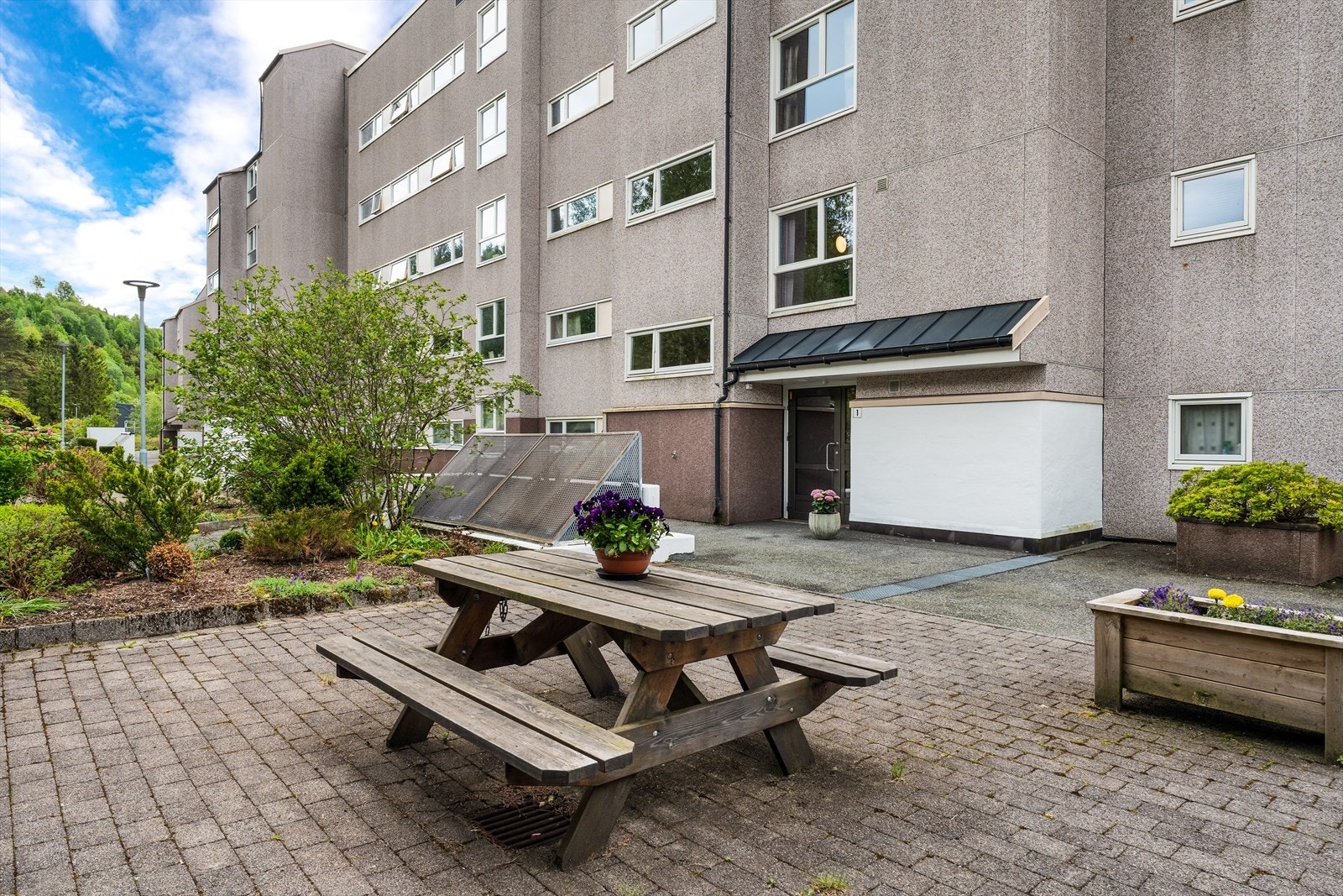 Felles eiet tomt i borettslaget som er pent opparbeidet med parkeringsplasser, gangveier, diverse grøntareal, lekeplass og torg i forkant Galleribilde