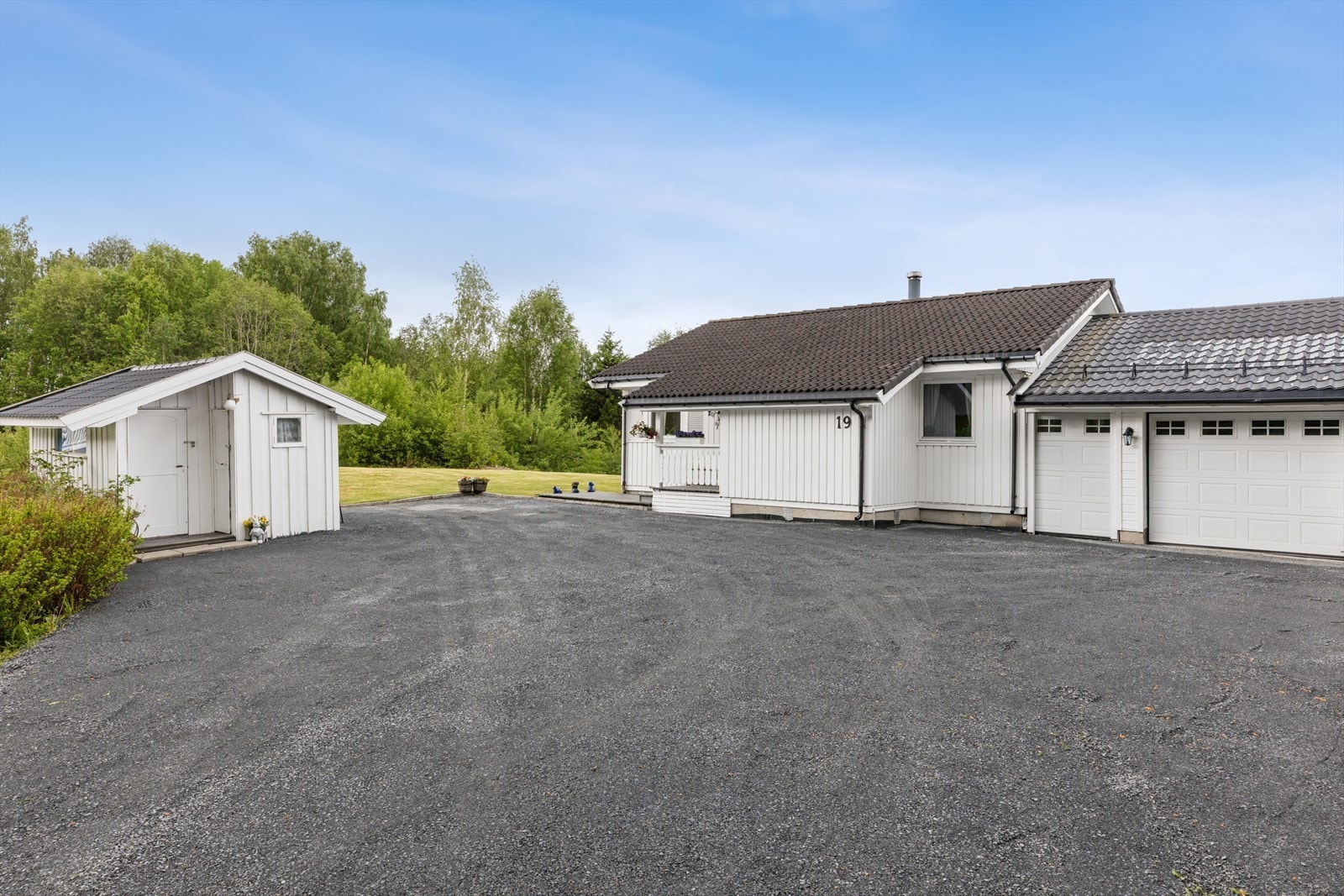 Romslig, gruset gårdsplass med gode parkeringsmuligheter i tillegg til garasje. Galleribilde