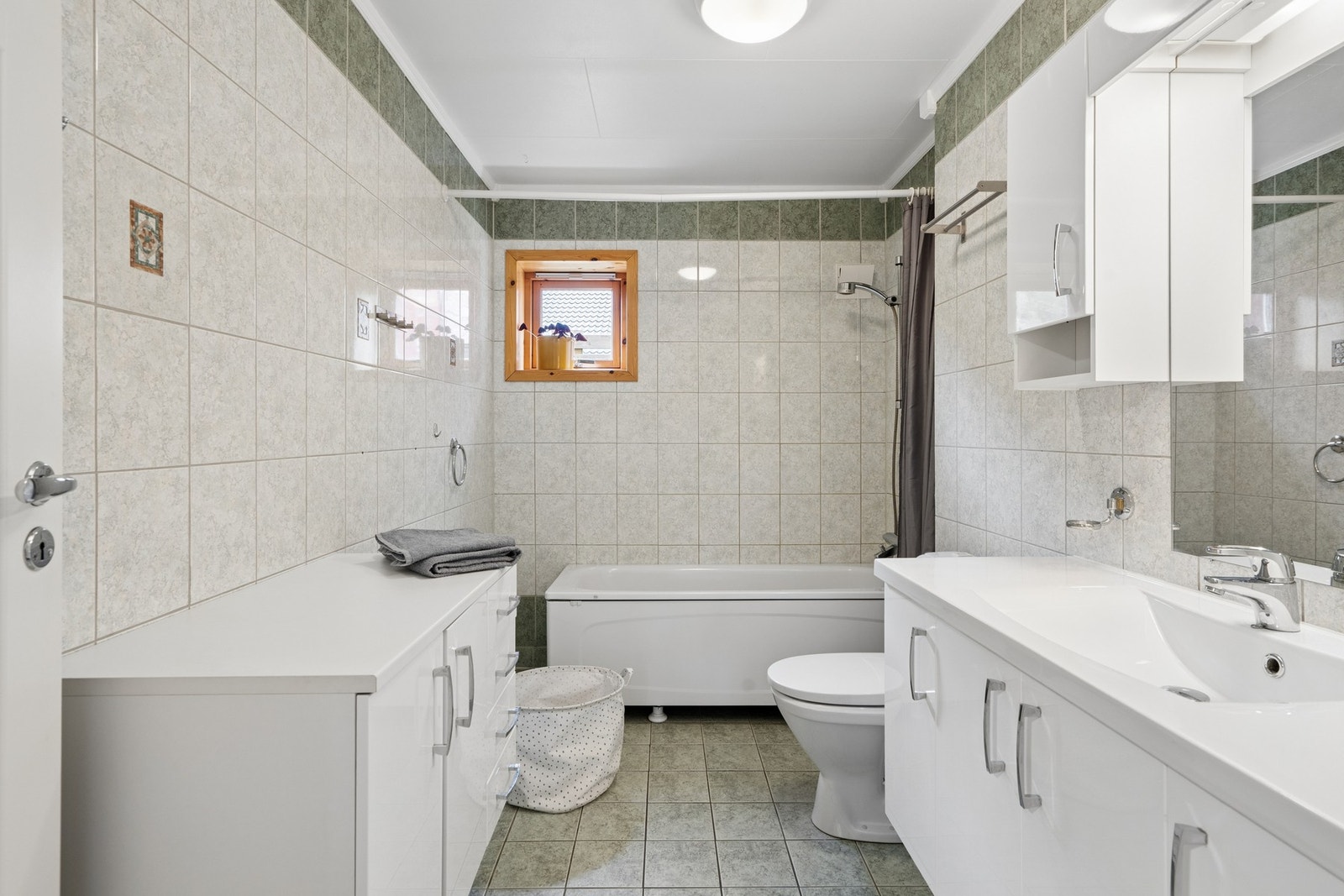 Badet har rikelig med oppbevaringsplass i skap og skuffer. Galleribilde