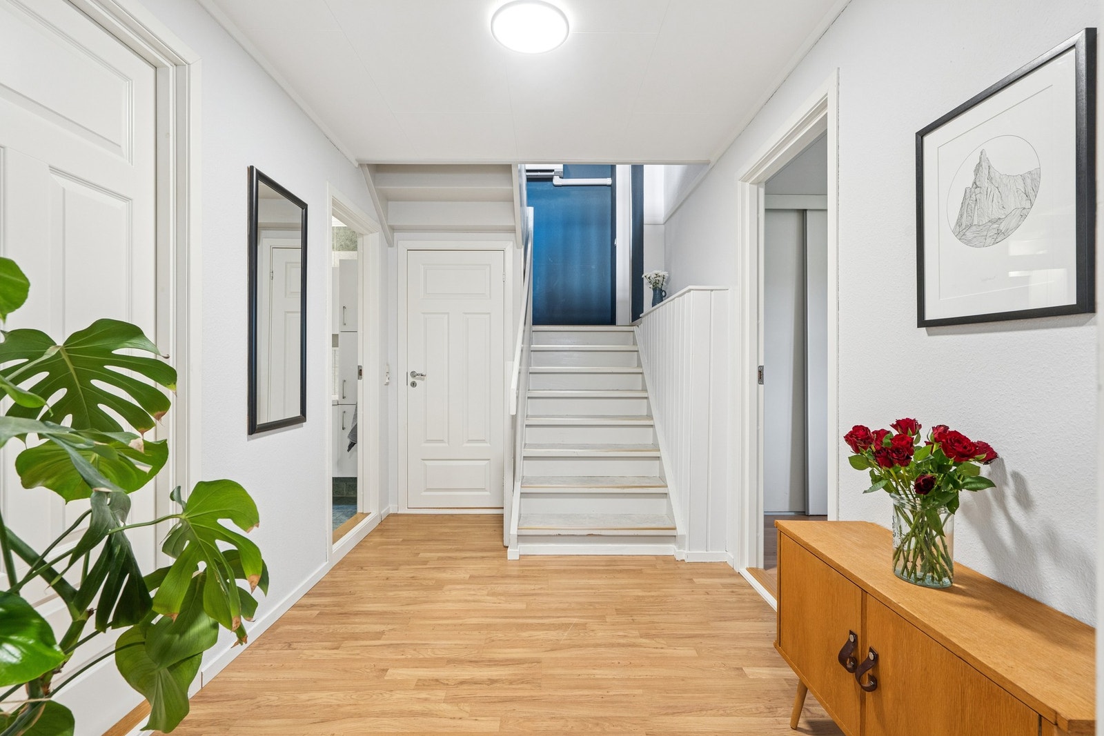 Lys og innbydende gang som fordeler til tre soverom, bad og trapp til andre etasje. Galleribilde
