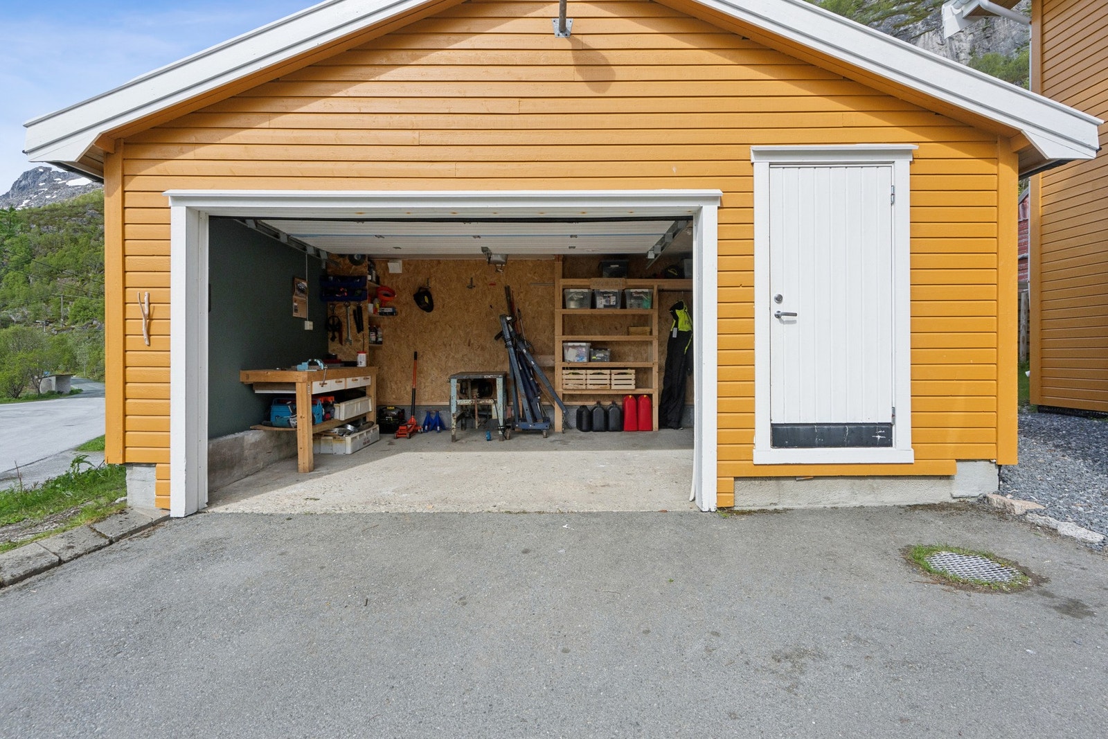 Garasje med plass til en liten bil, verktøy og lagring. Det er installert EL-bil lader. Galleribilde