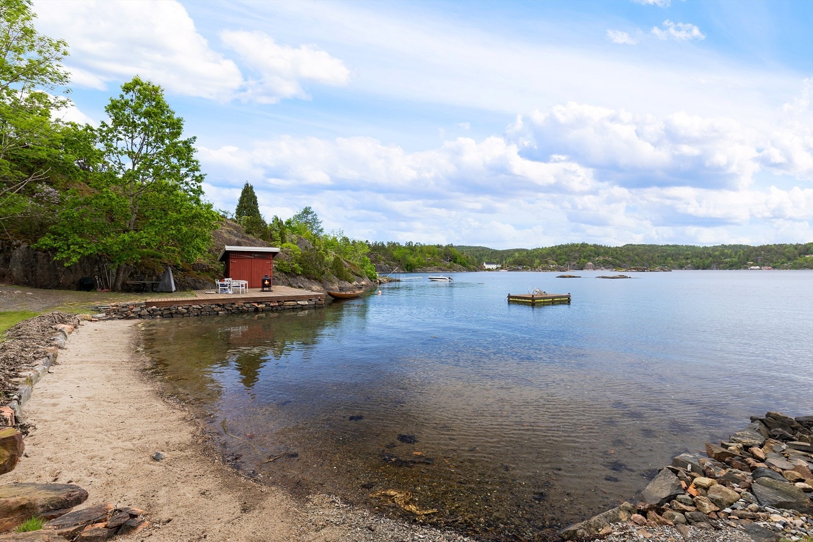 Tomten har lang strandlinje med brygge, sjøbod og strand. Galleribilde