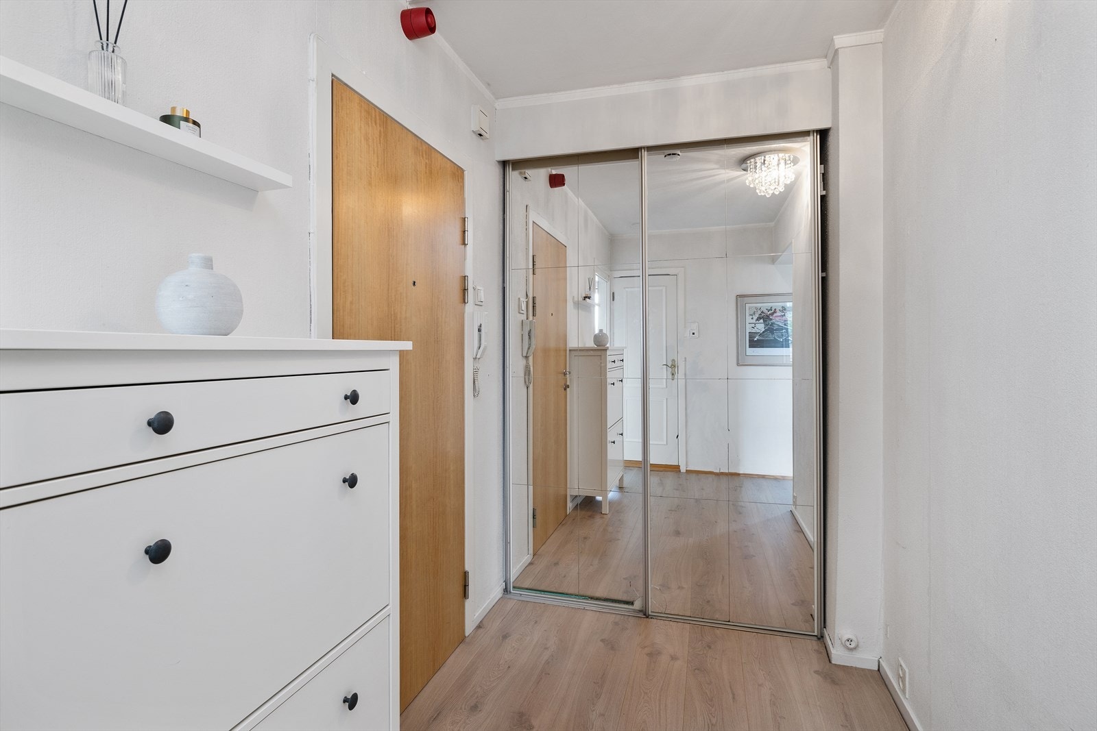 En praktisk skyvedørsgarderobe med speilfronter gir bra
med oppbevaringsplass i entréen. Galleribilde