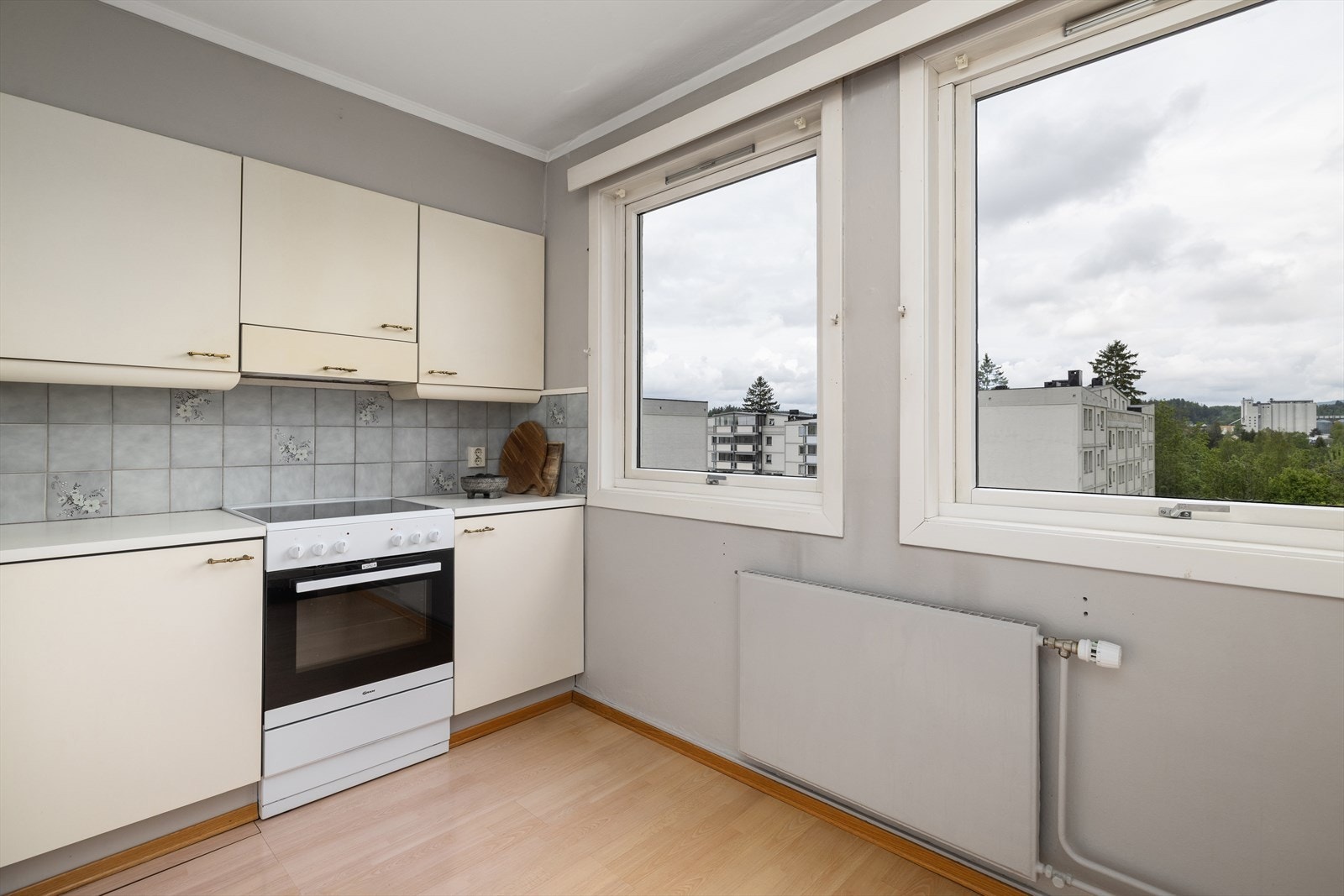 Kjøkkeninnredning med glatte fronter og laminat benkeplate. Kjøkkenventilator har avtrekk ut. Galleribilde
