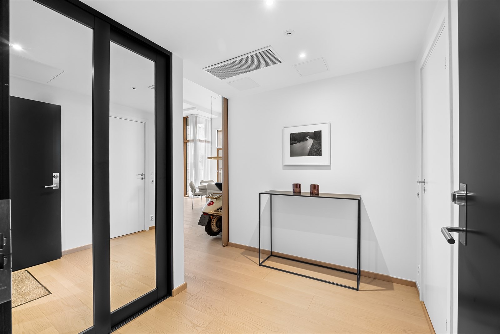 Velkommen inn! Man ankommer boligen i en innbydende og romslig entré med innebygget skyvedørsgarderobe med speilfronter - både stilfull og plassbesparende. Galleribilde