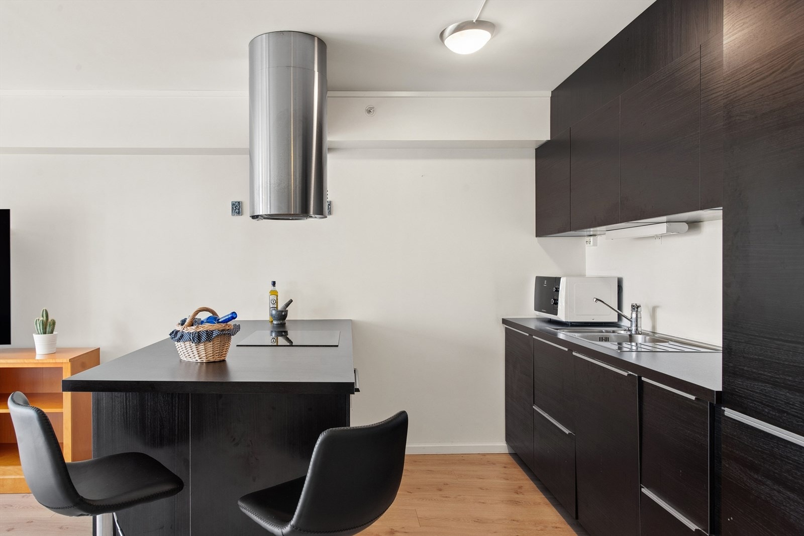 Kjøkkeninnredningen er fra IKEA og står i stilren kontrast med fargene i leiligheten og har integrerte hvitevarer. Galleribilde