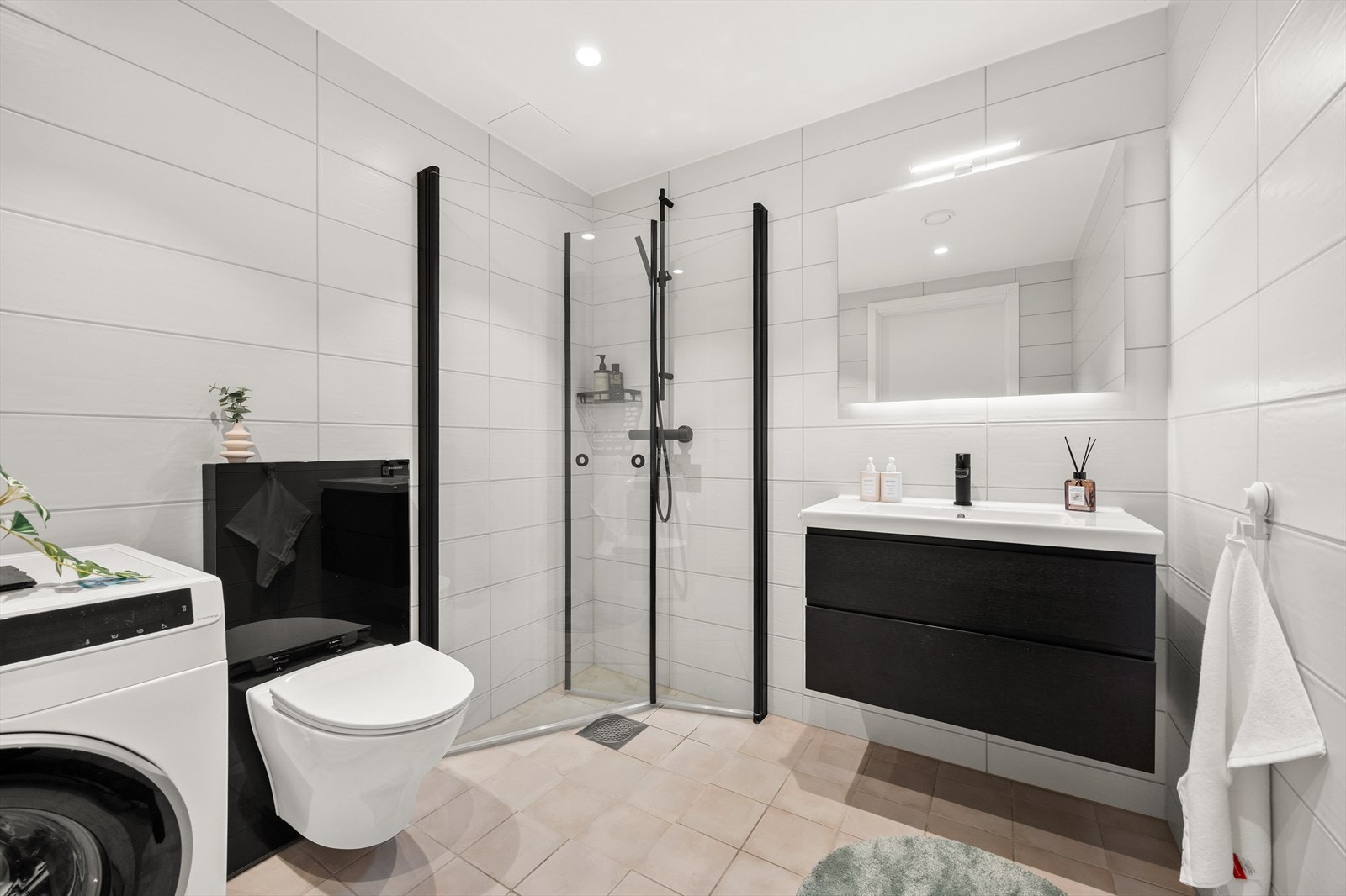Badet har et stilrent preg med flislagte gulvflater som er oppvarmet med vannbåren gulvvarme, samt downlights i taket. Galleribilde