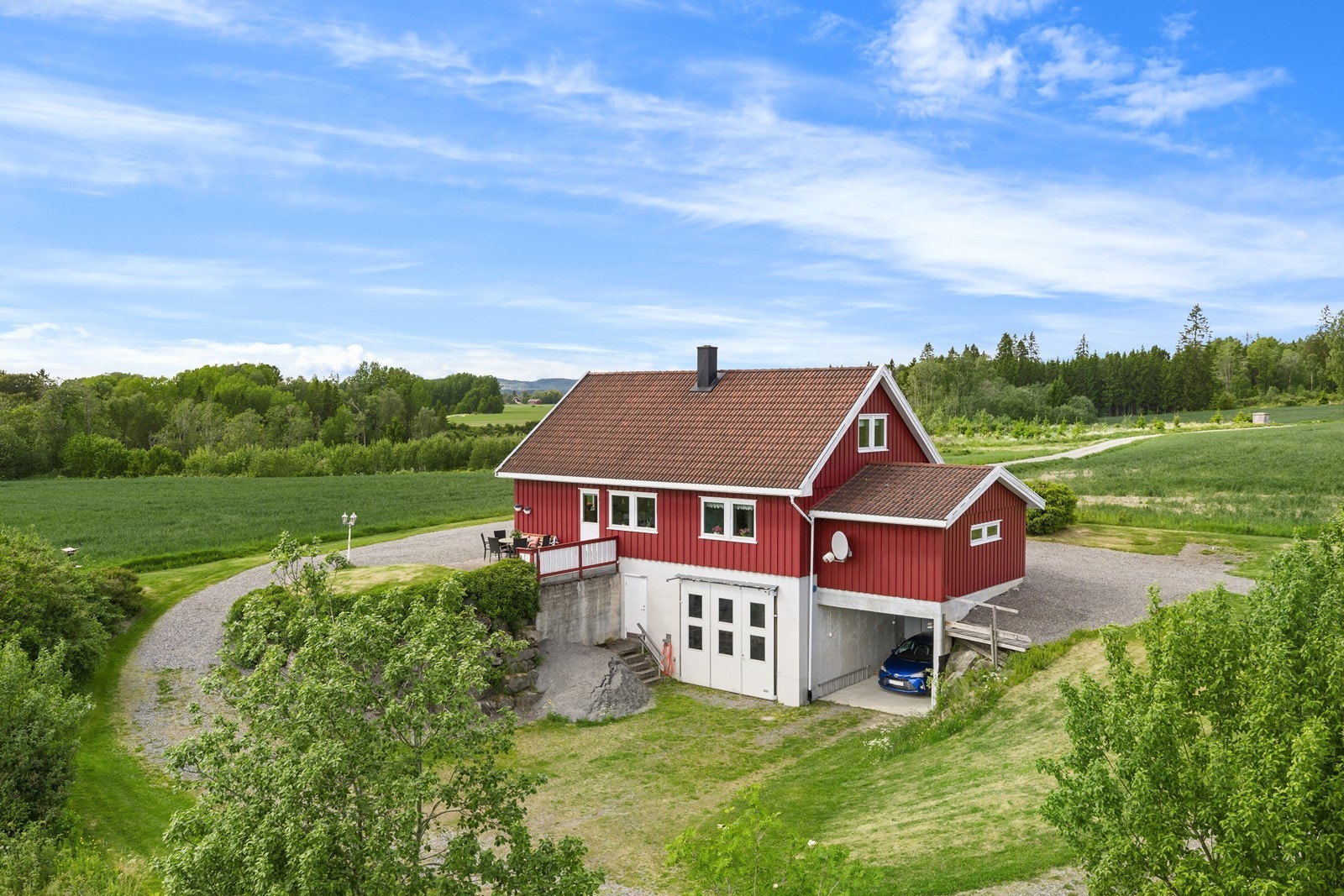 Eiendommen inkluderer en stor hage og skrånende terreng rundt bygningen. Galleribilde