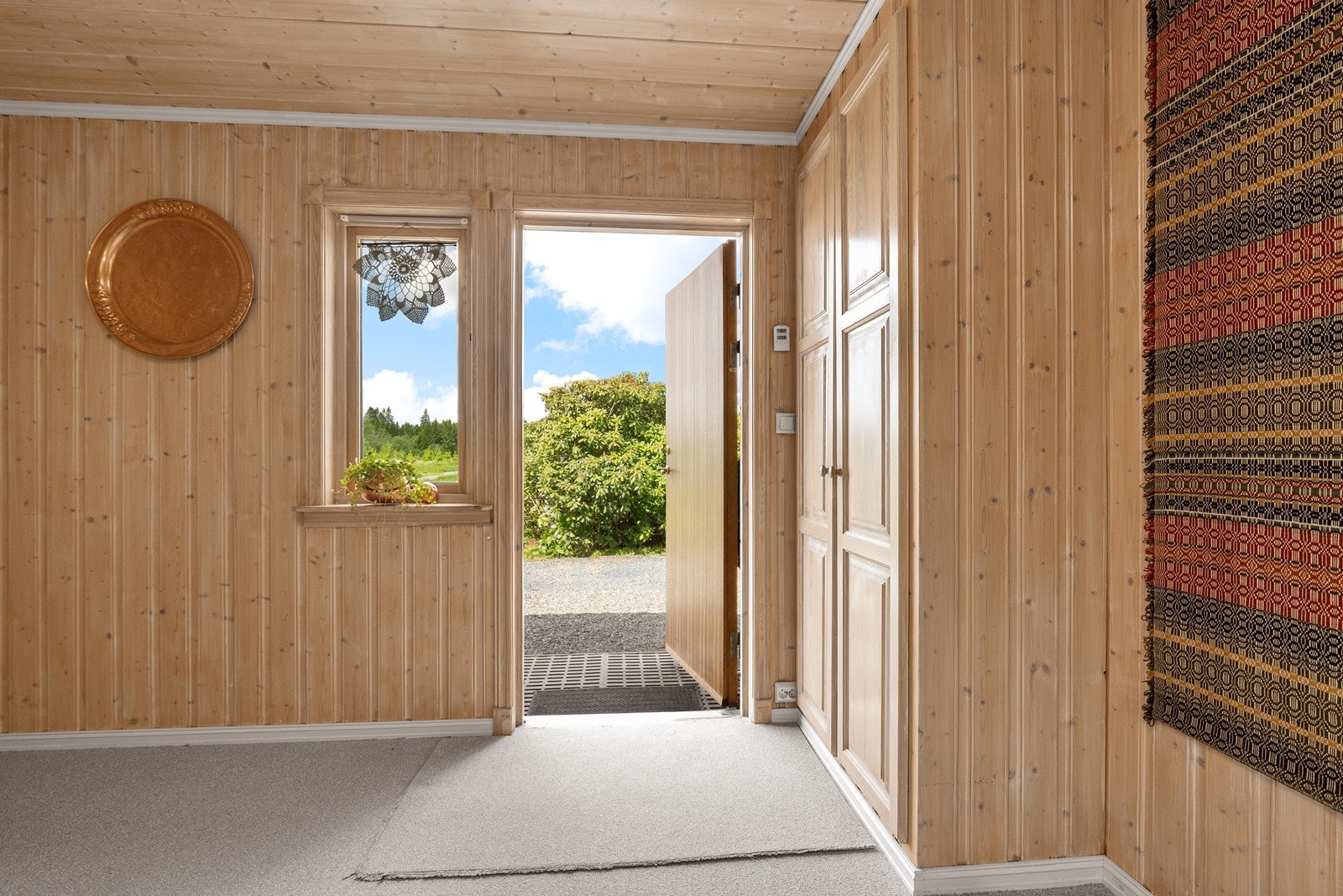Hallen inneholder møbelsnekkerbygd garderobe, samt varmekabler på gulvet. Galleribilde