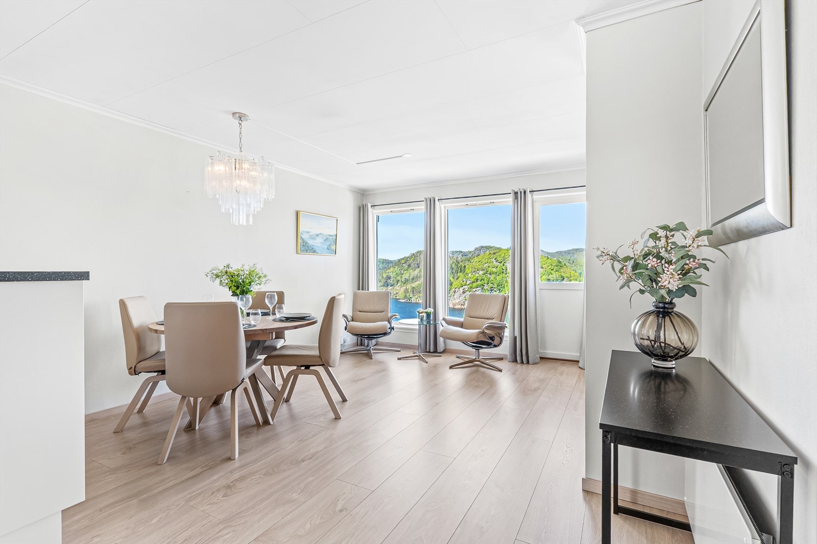 Den åpne planløsningen mellom stue og kjøkken gir god romfølelse! Store vindusflater i front gir godt med dagslys inn i boligen. Herfra er det også direkte utgang til egen terrasse. Galleribilde