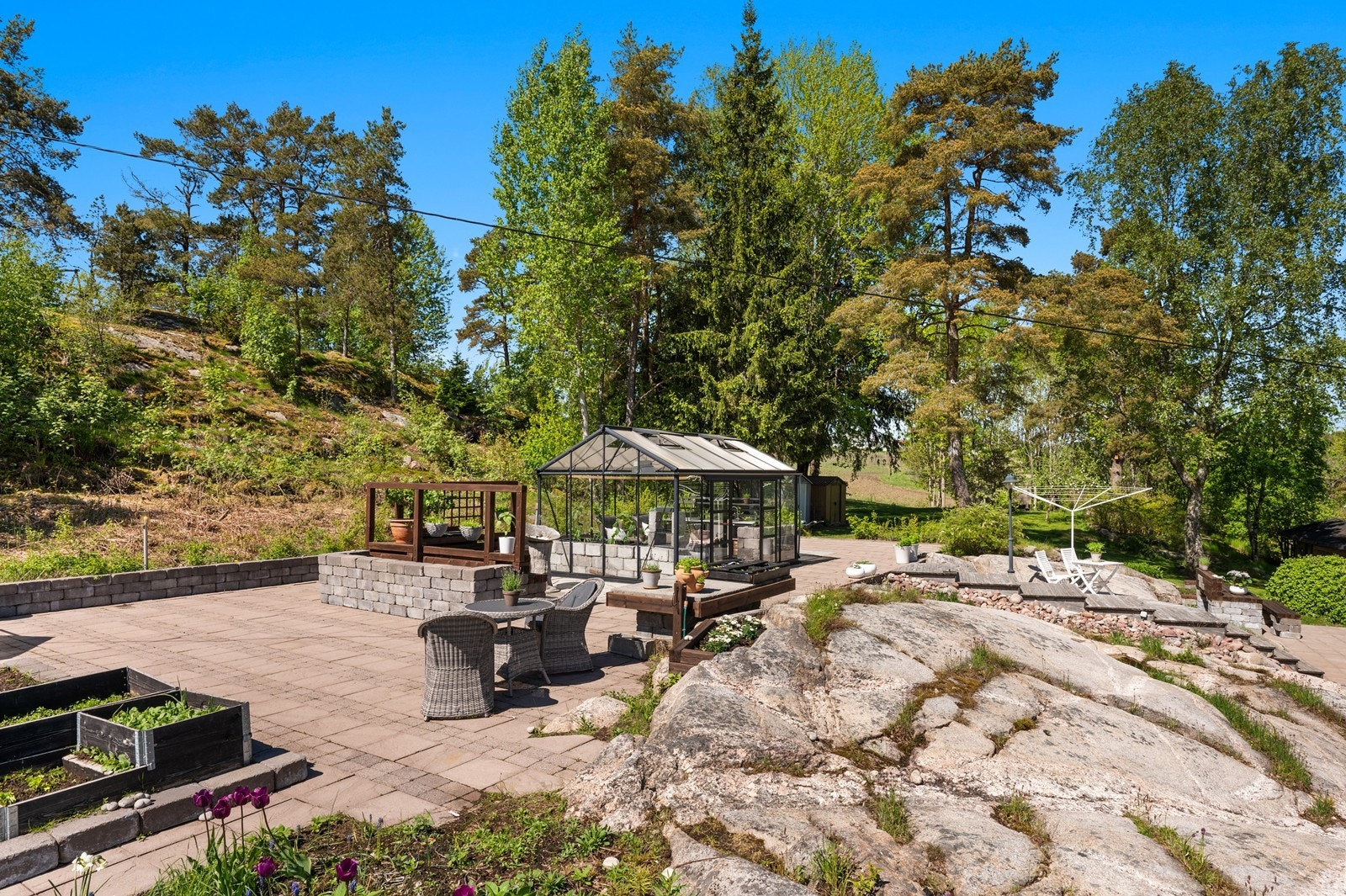 Tomten har flere soner, inkludert et område med plantekasser og pallekarmer. Galleribilde