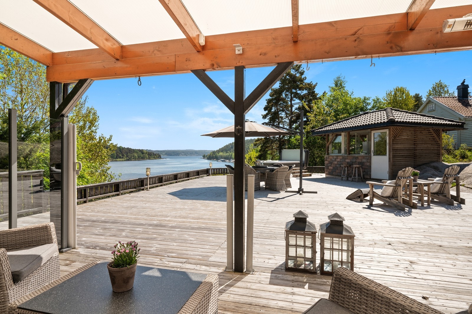 Fra den overbygde uteplassen er det åpen utsikt mot vannet. Her er det også satt opp uttrekkbar vindsskjerming. Galleribilde