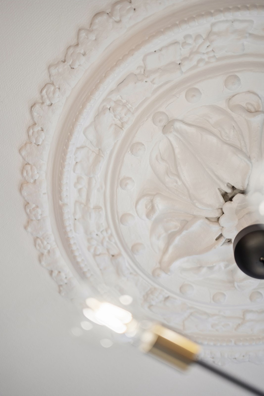 Originale detaljer som takrosett er bevart og komplementerer den klassiske stilen. Galleribilde
