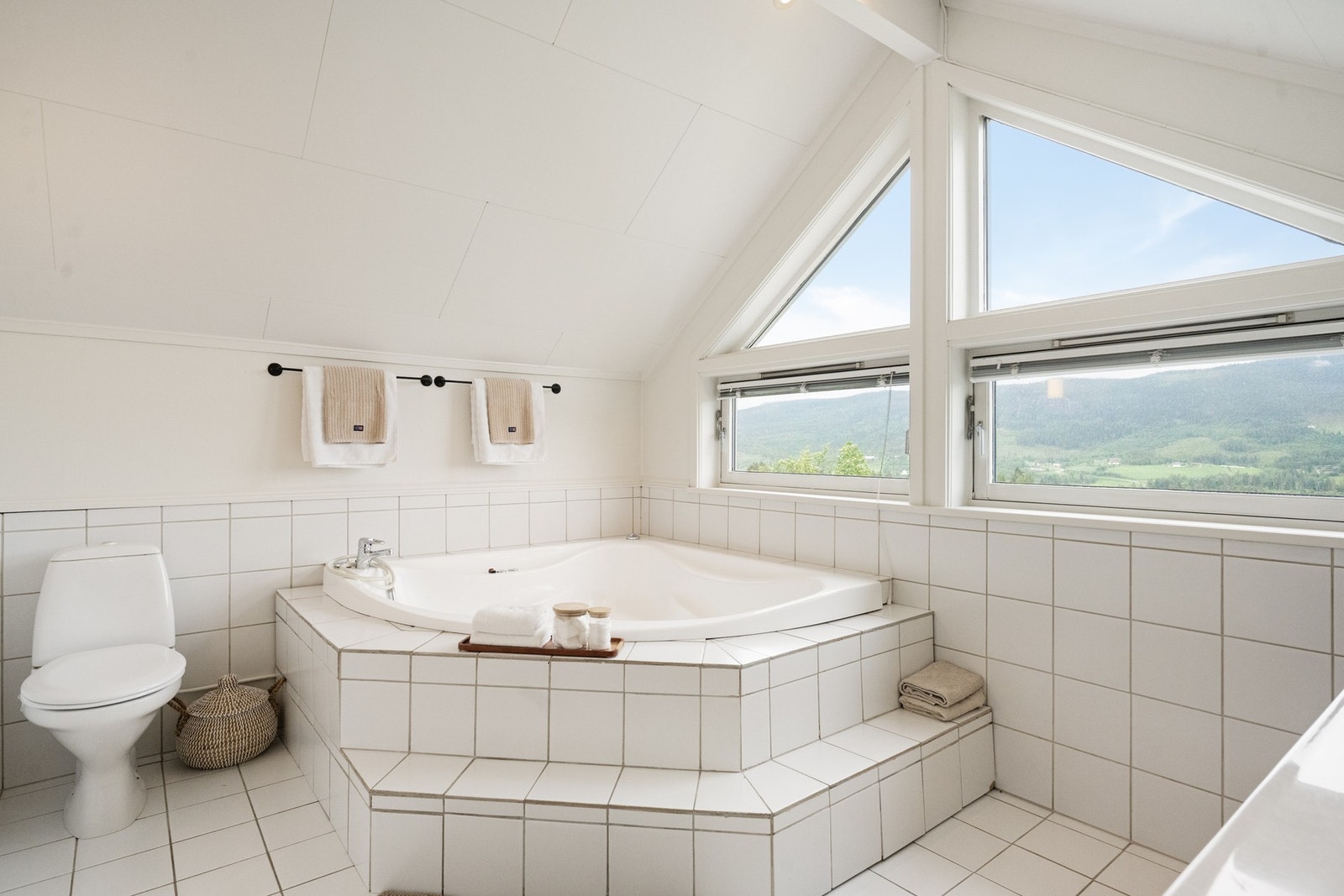 Badet er romslig og innredet med toalett, stor boblebadekar og baderomsinnredning med nedfelt servant. Galleribilde