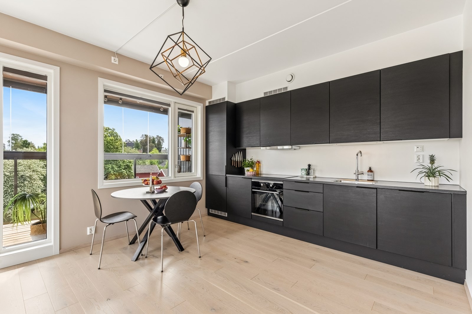 Kjøkkeninnredningen er moderne med glatte, mørke fronter og benkeplate i laminat. Galleribilde