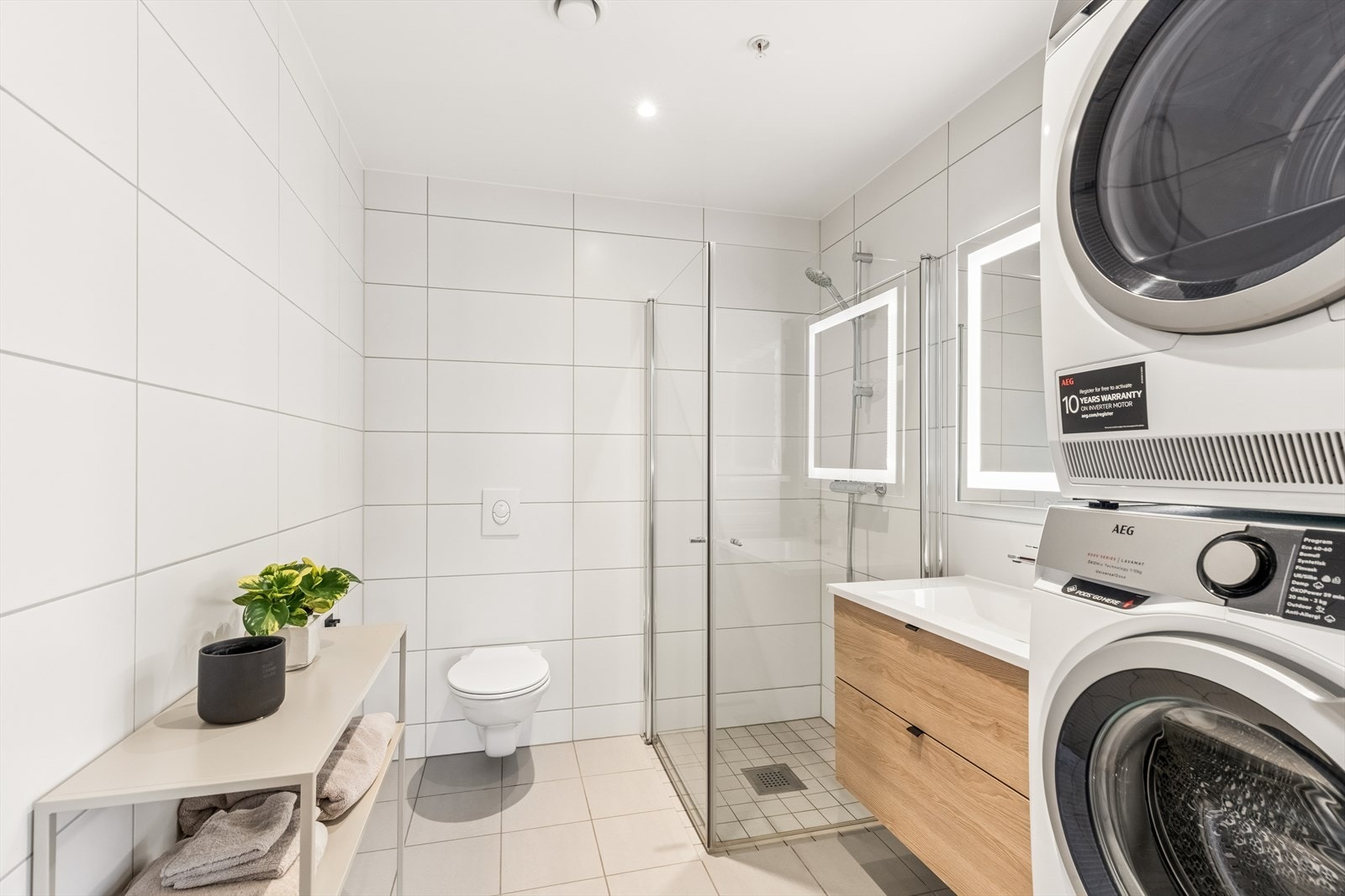 Badet har elektriske varmekabler i gulvet, vegghengt toalett og dusjhjørne med innfellbare glassdører. Galleribilde