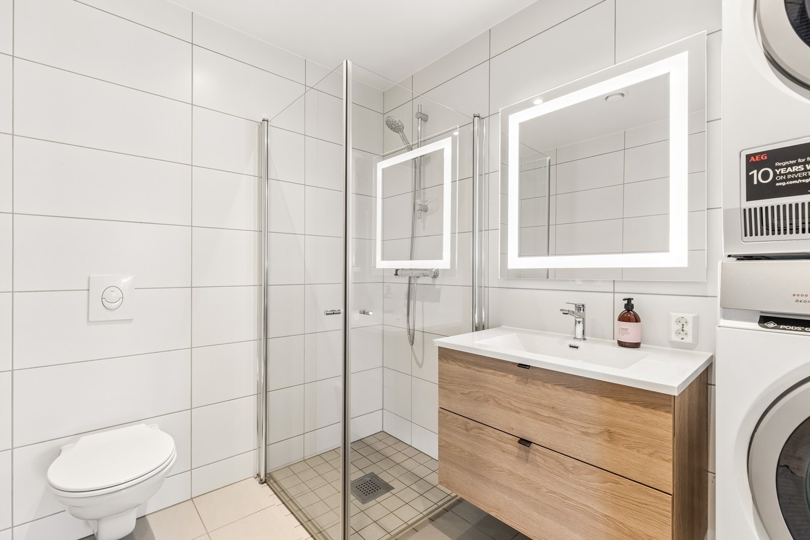 Baderomsinnredning med nedfelt servant og speil med integrert belysning. Galleribilde