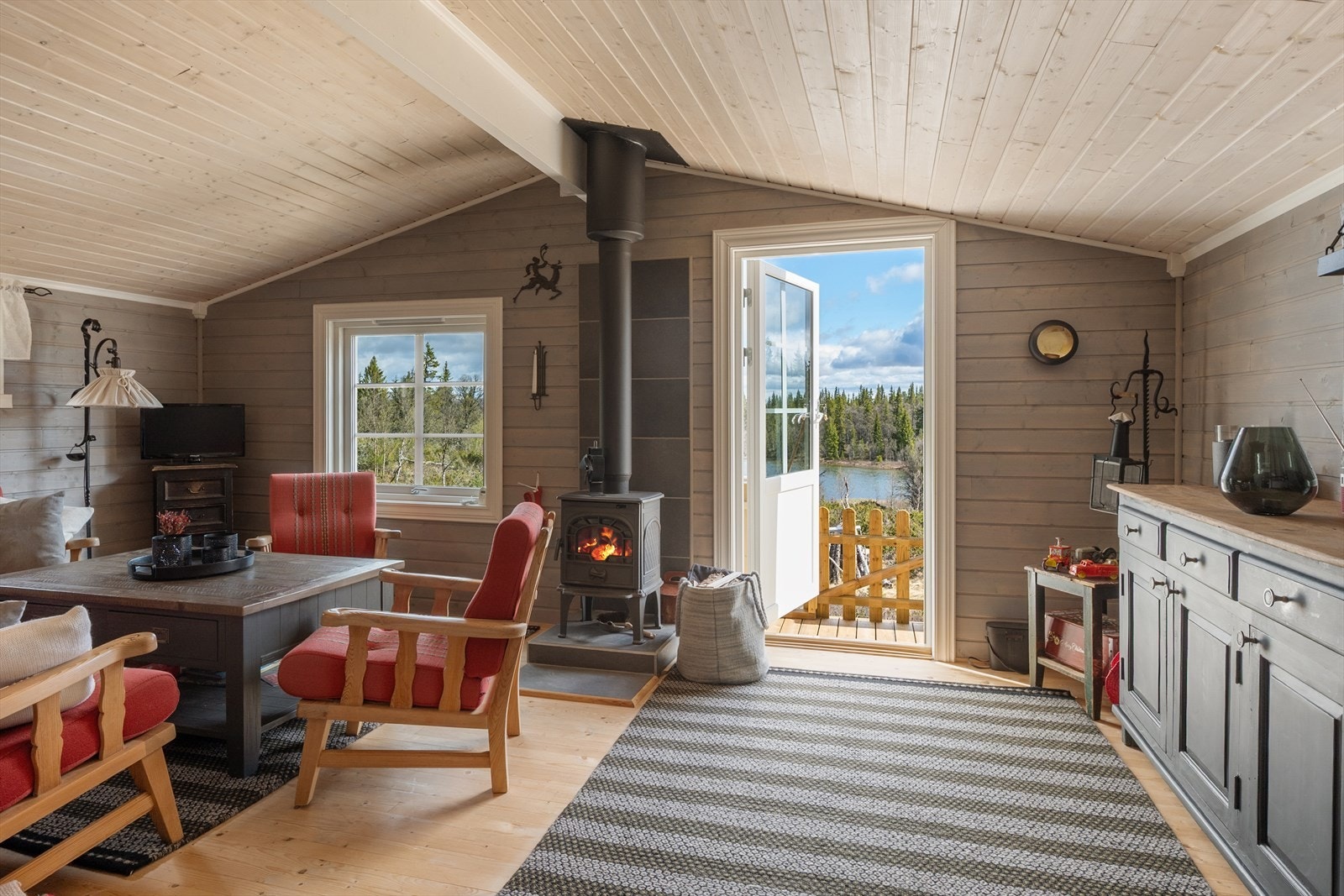 Stua har en sentralt plassert vedovn for varme og hygge, og utgang til den ene terrassen. Galleribilde