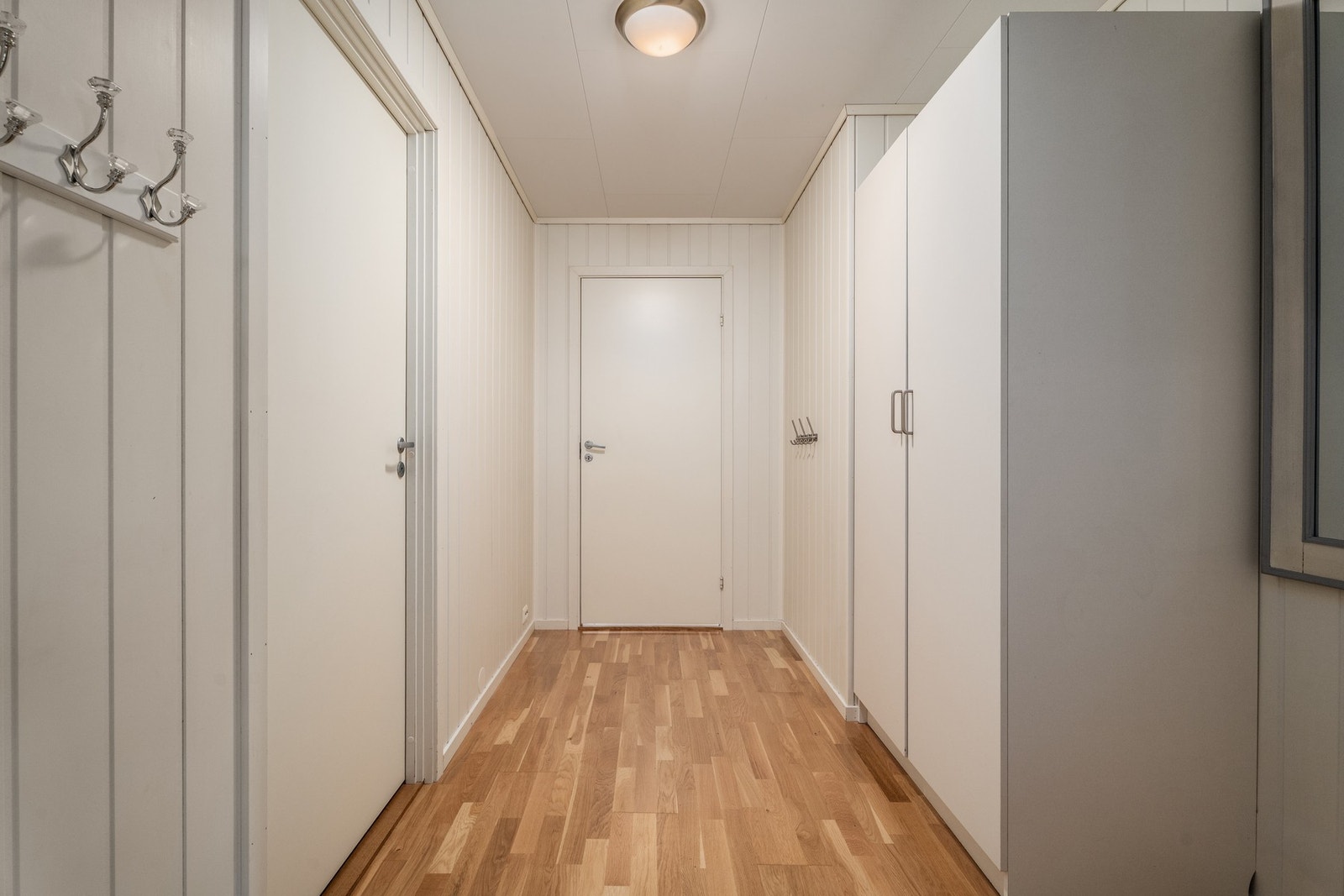 Entré med mulighet for oppbevaring, vaskerom til venstre og stuen videre fremover. Galleribilde