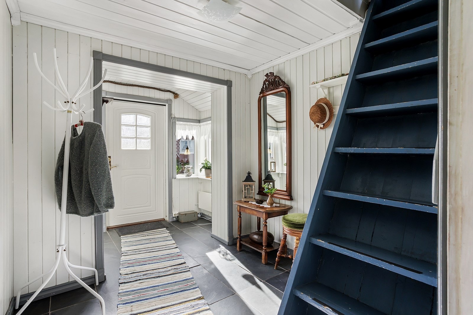 Rommet tar imot deg med flislagt gulv og hvitmalt trepanel på vegger og himling. Galleribilde