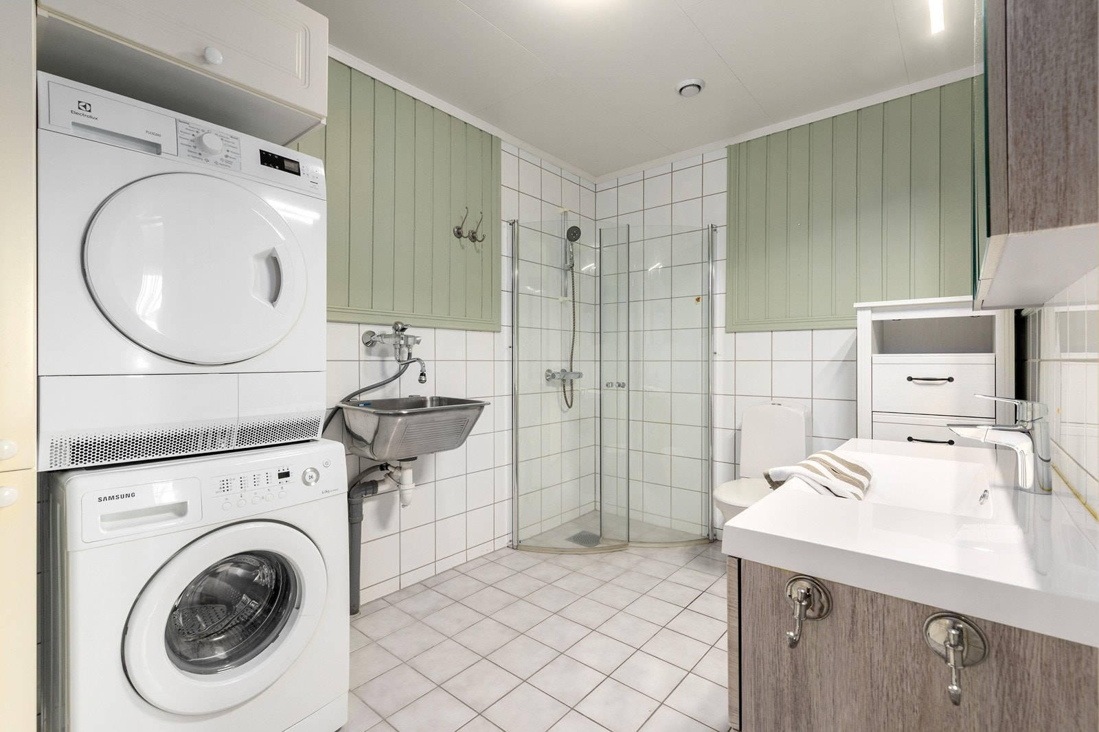 Badet er praktisk innredet med dusjhjørne og opplegg for vaskemaskin. Galleribilde