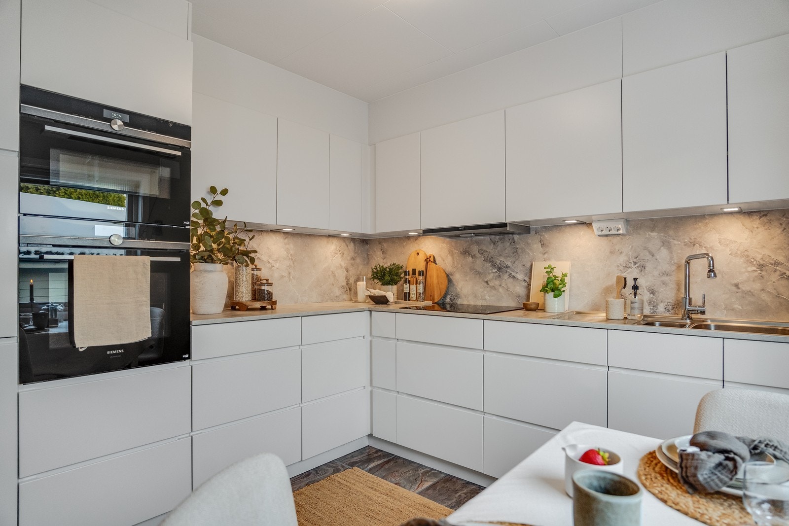 Flott og moderne kjøkken fra Kvik, utført med slette fronter og benkeplate av laminat med nedfelt vask. Galleribilde