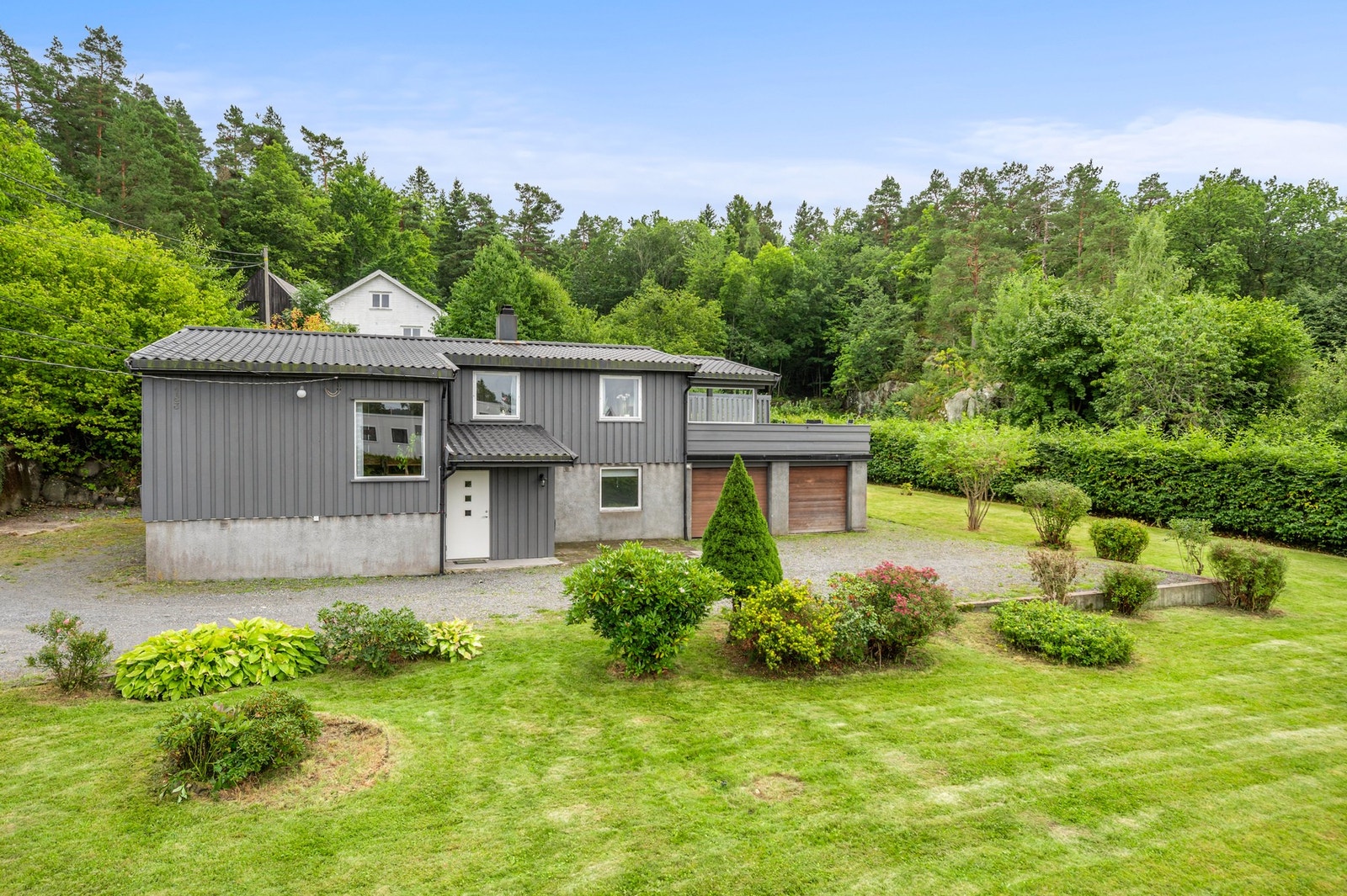 Opparbeidet hage med plen, beplantning og god avstand rundt boligen. Galleribilde