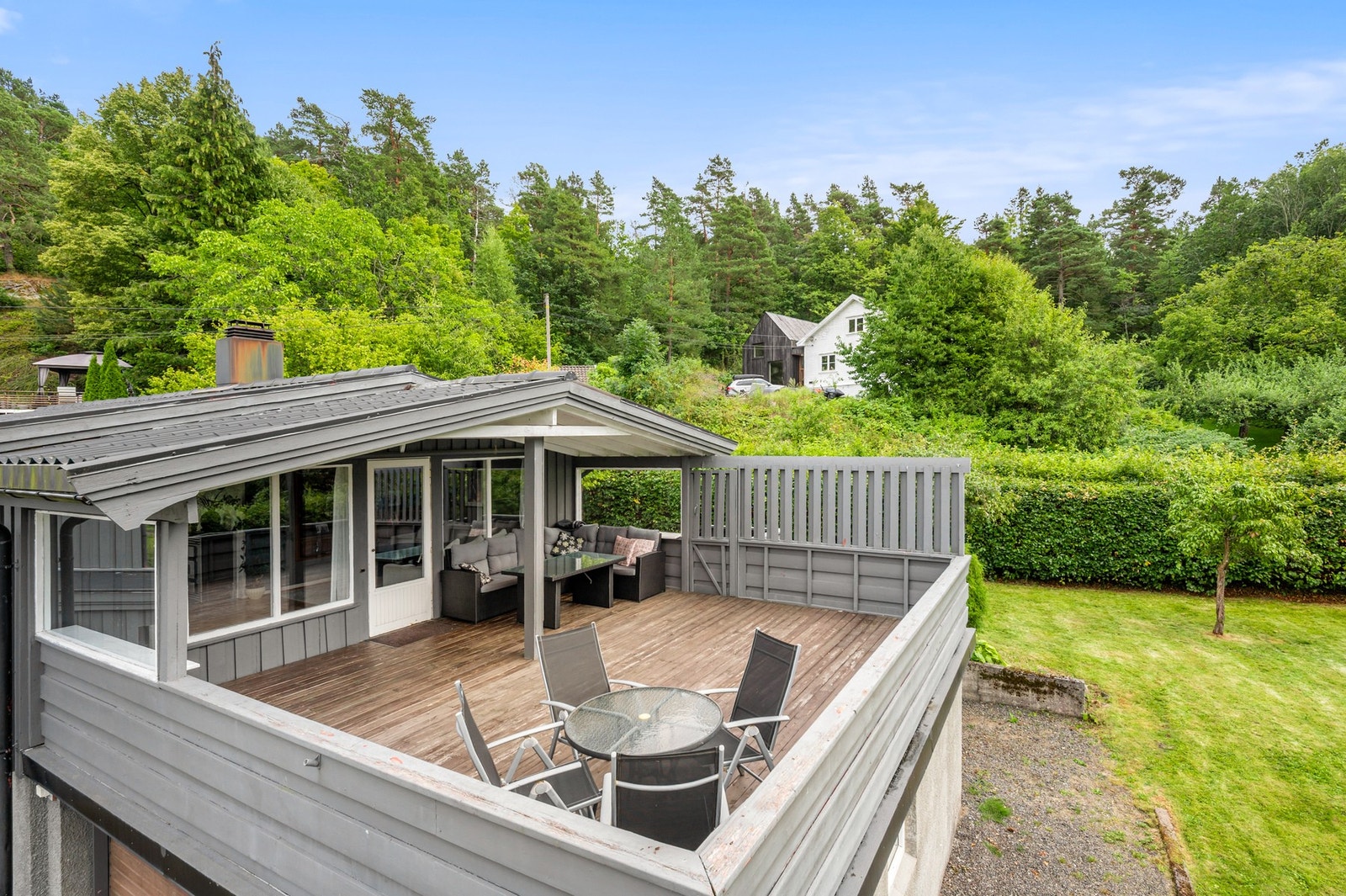 Stor terrasse med flere brukssoner og hyggelig utsyn mot grønne omgivelser. Galleribilde
