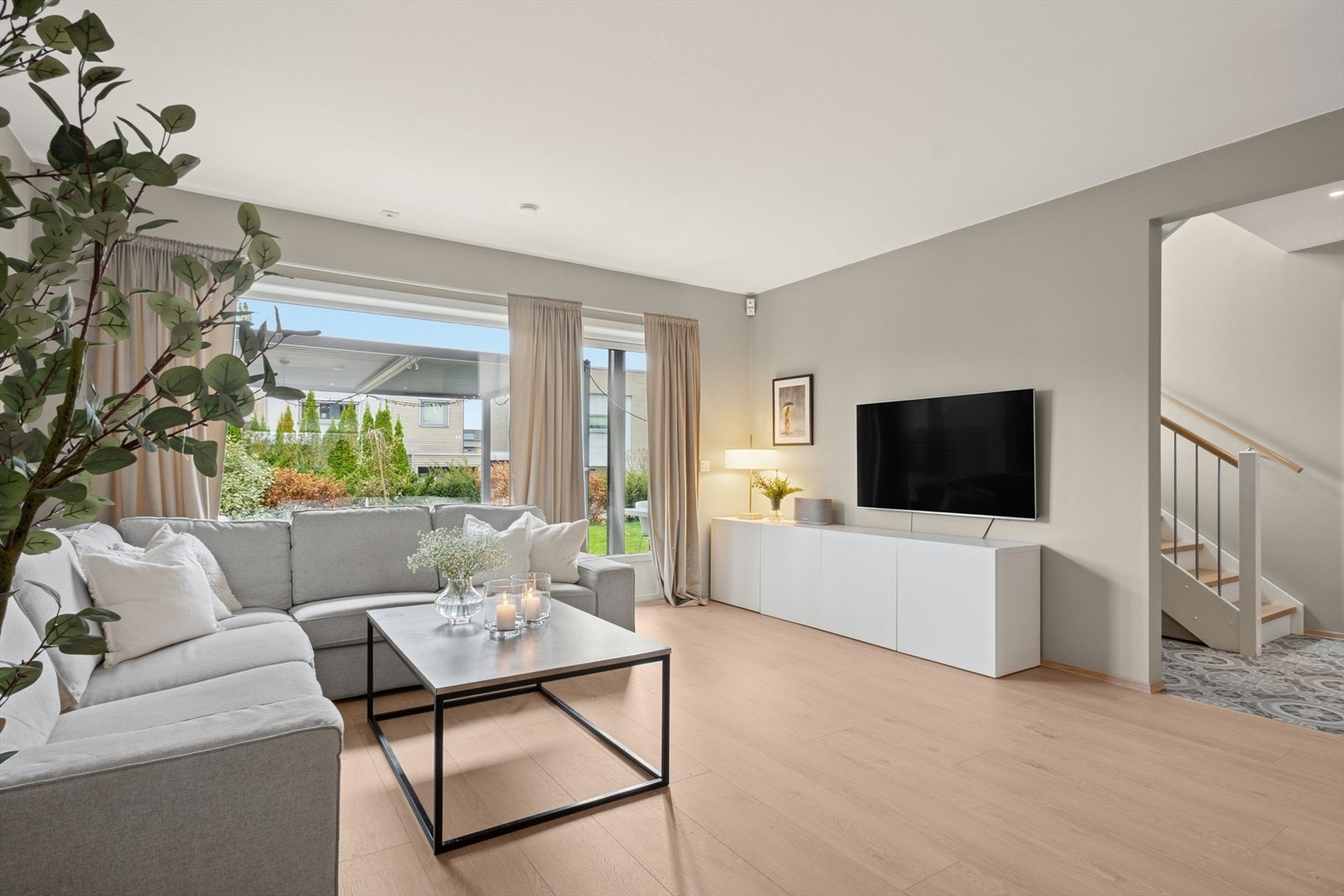 Videre inn i boligen er det en lys og romslig stue med utgang til terrasse og hage Galleribilde