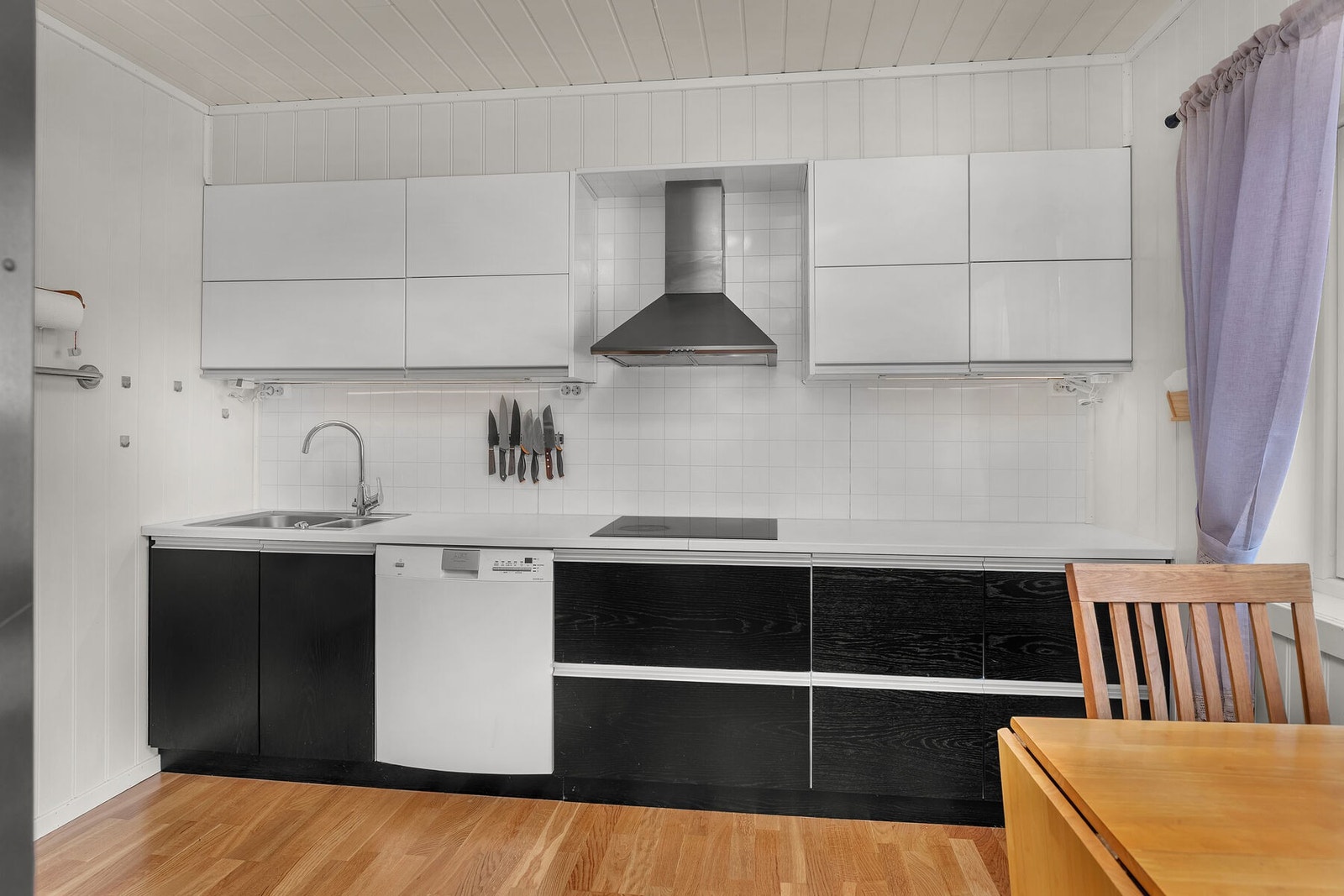 Kjøkkeninnredning med glatte fronter, laminatbenkeplate og ventilator med avtrekk ut. Galleribilde