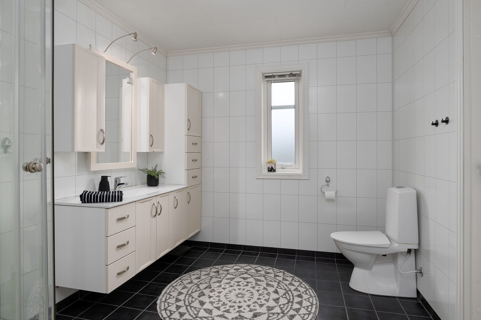 Badet har flislagt gulv med elektriske varmekabler og våtromsplater på veggene. Galleribilde