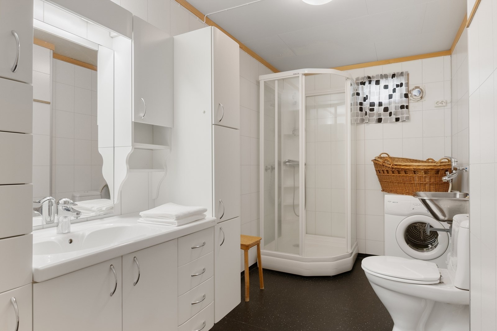 Badet i første etasje er kombinert vaskerom med dusjkabinett og rikelig med skapplass. Galleribilde