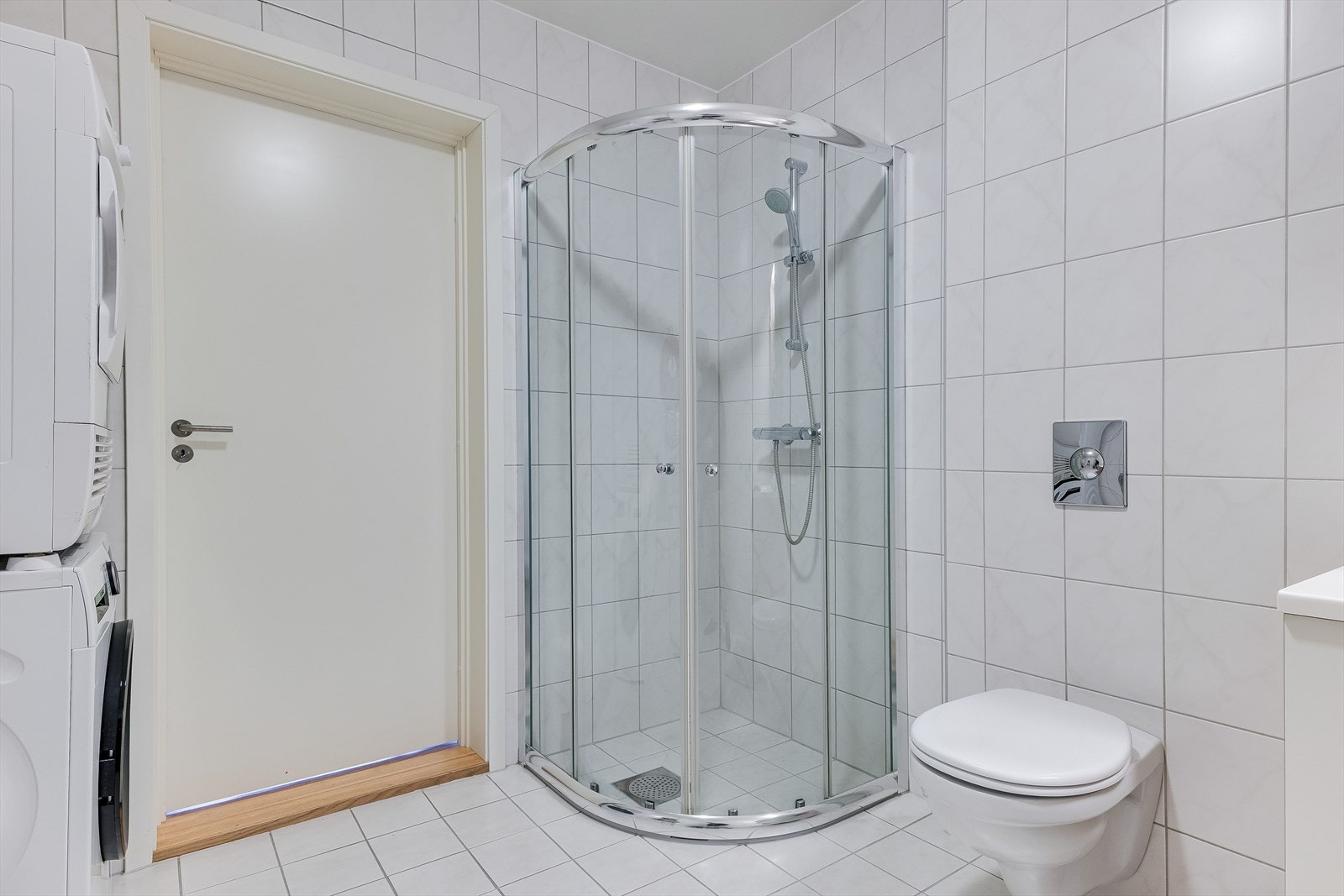 Badet er utstyrt med dusjhjørne, vegghengt toalett, opplegg for vaskemaskin og vannbåren gulvvarme. Galleribilde