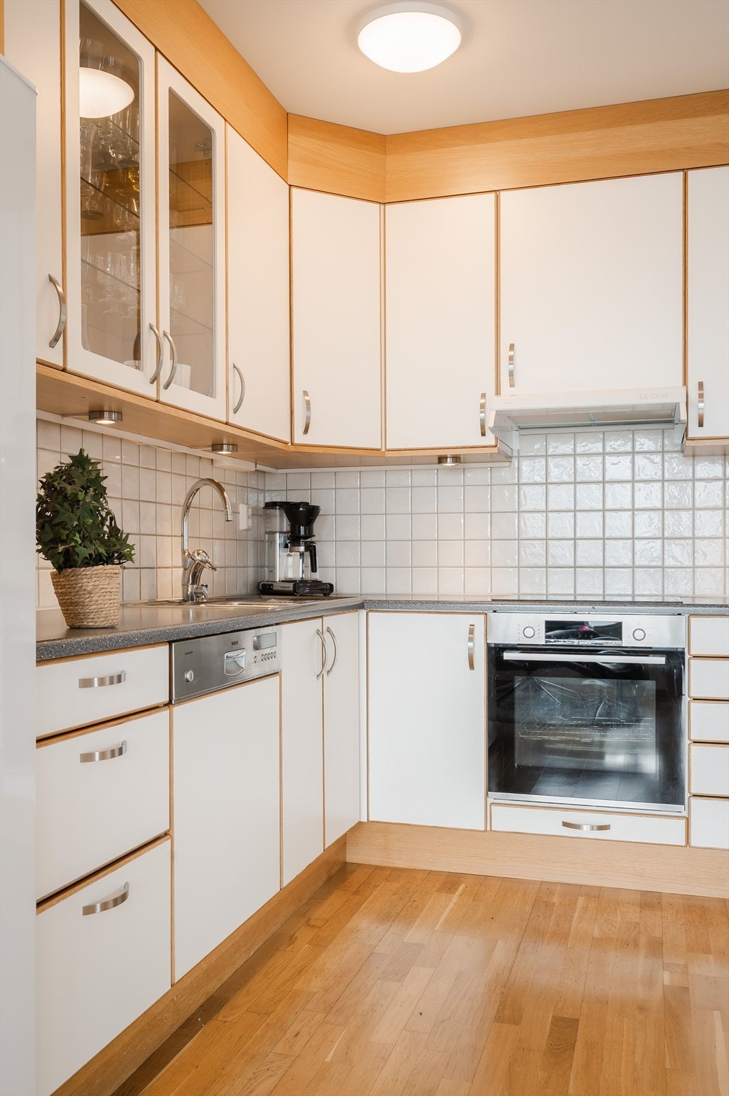 Benkeplaten er av laminat og har dobbel oppvaskkum i rustfritt stål. I benkeryggen er det fliser for enkel rengjøring. Galleribilde